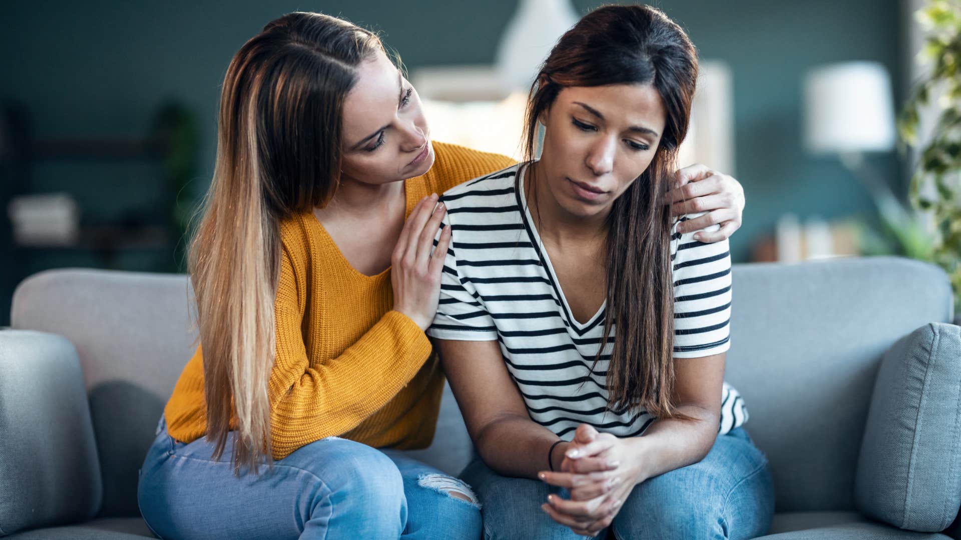 woman comforting friend on couch