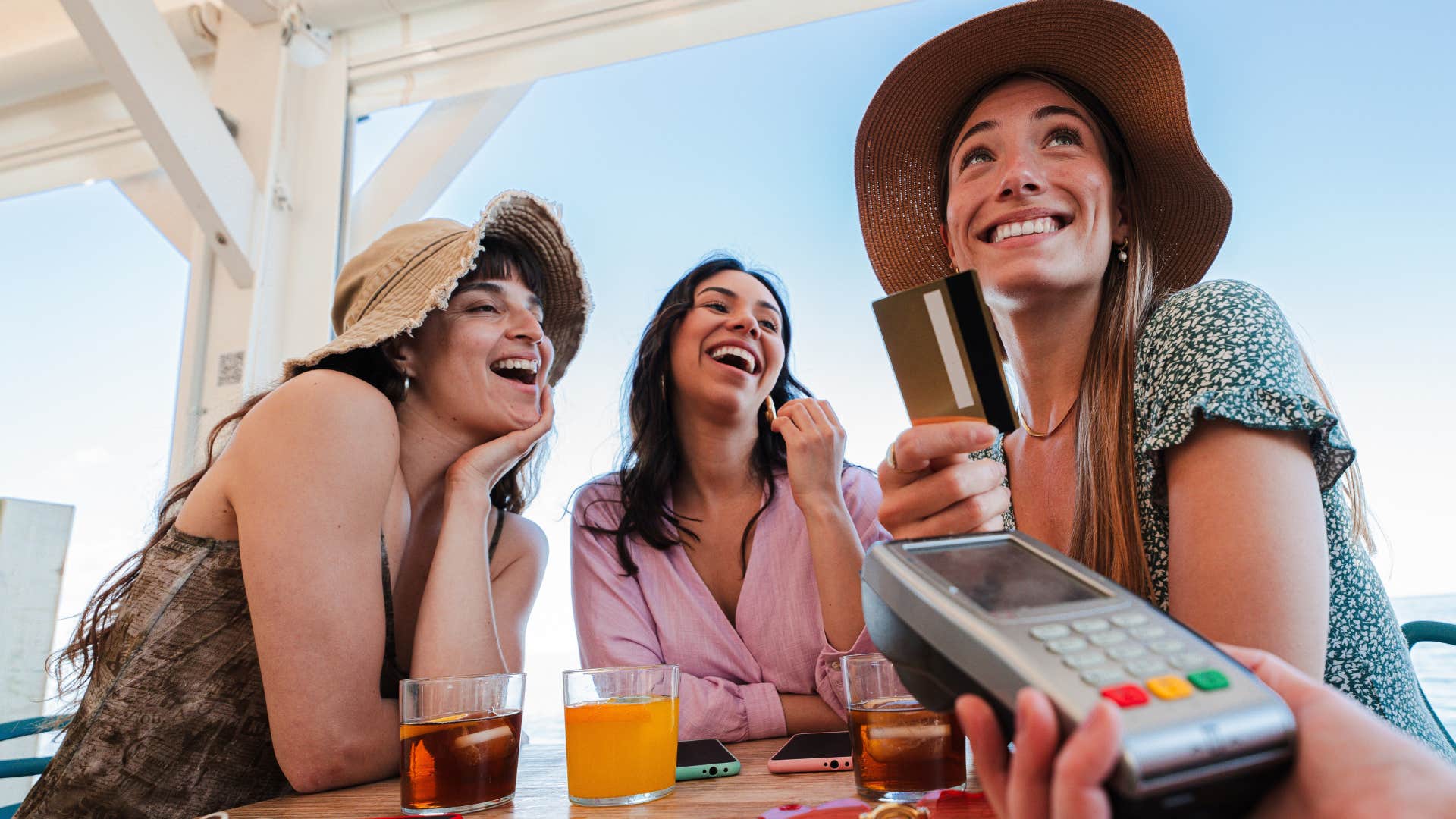 Woman buying rounds for the table with friends.
