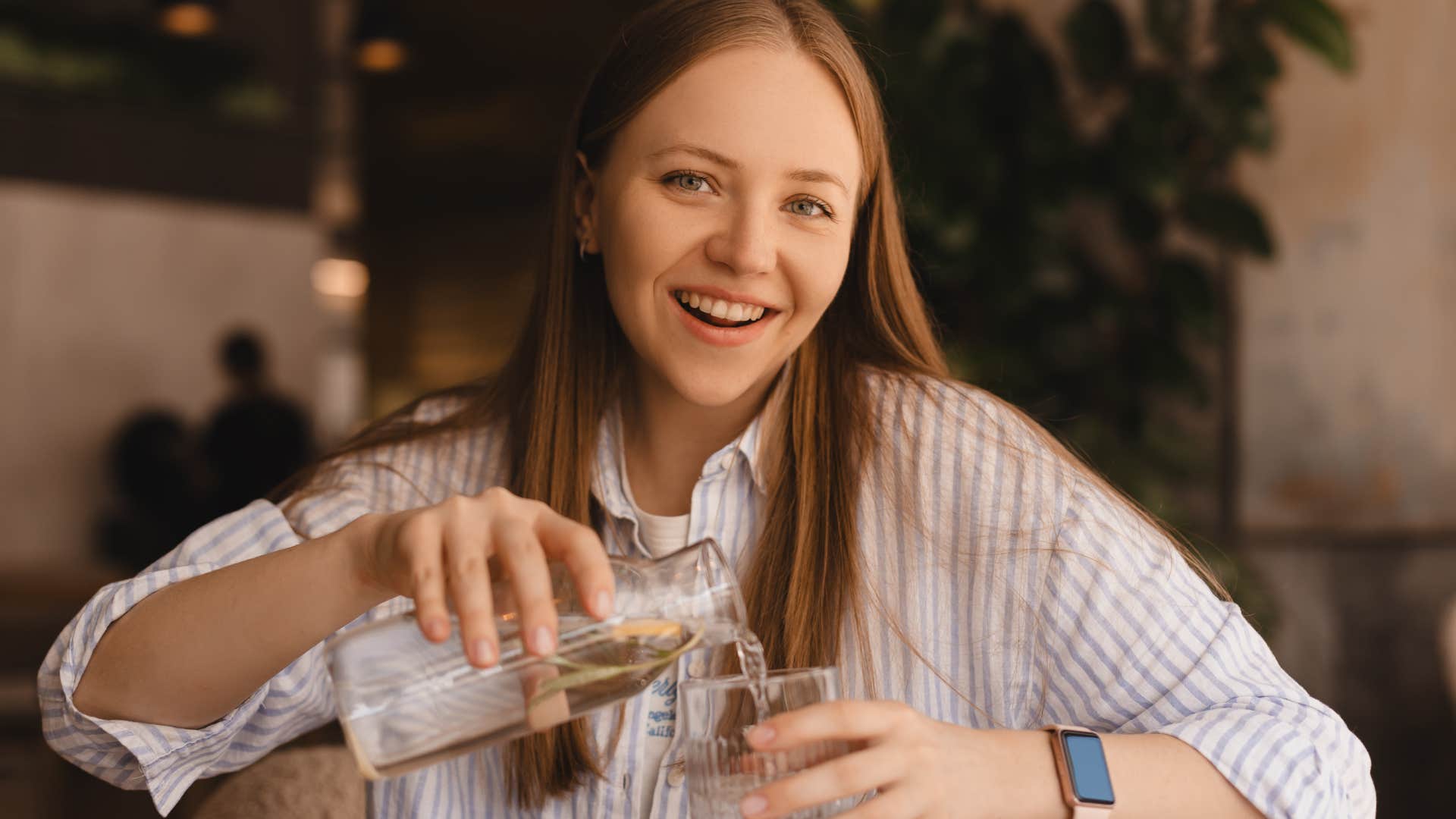 Woman ordering bottled water over tap at a restaurant.