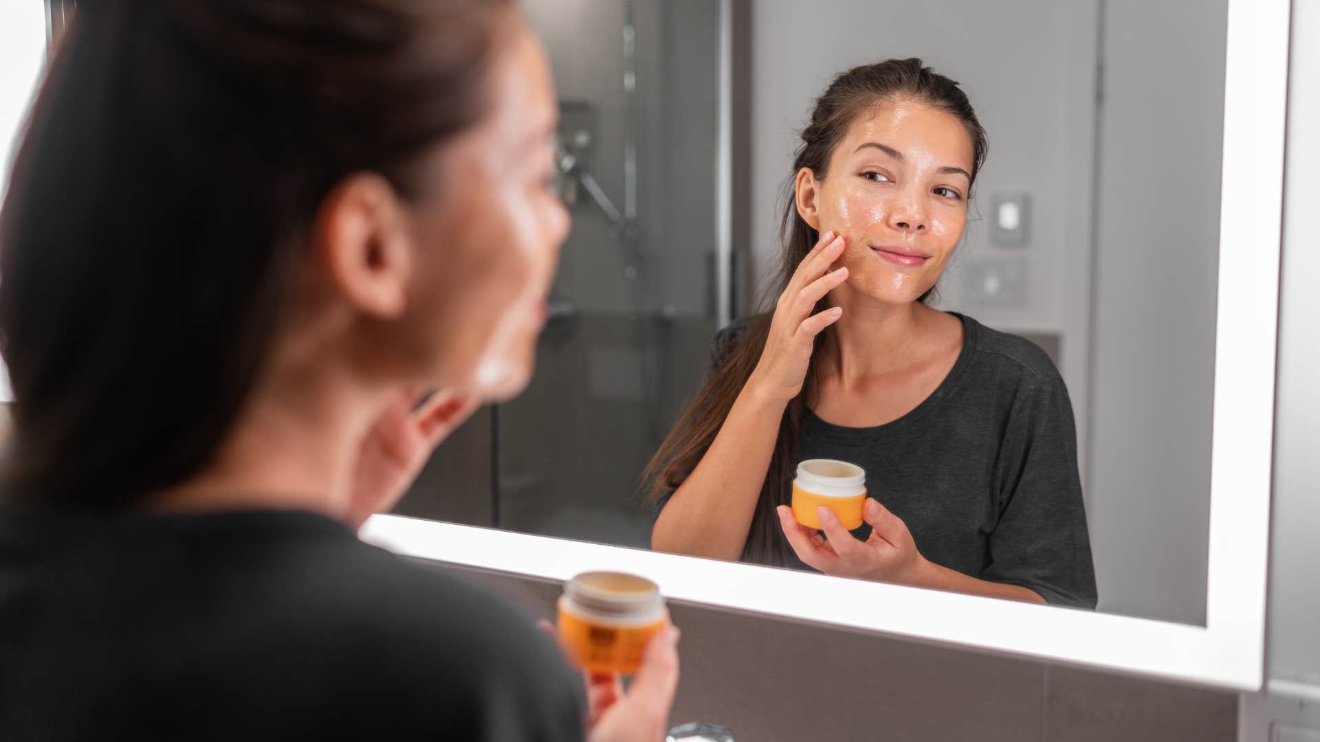 woman using trendy beauty products in the mirror