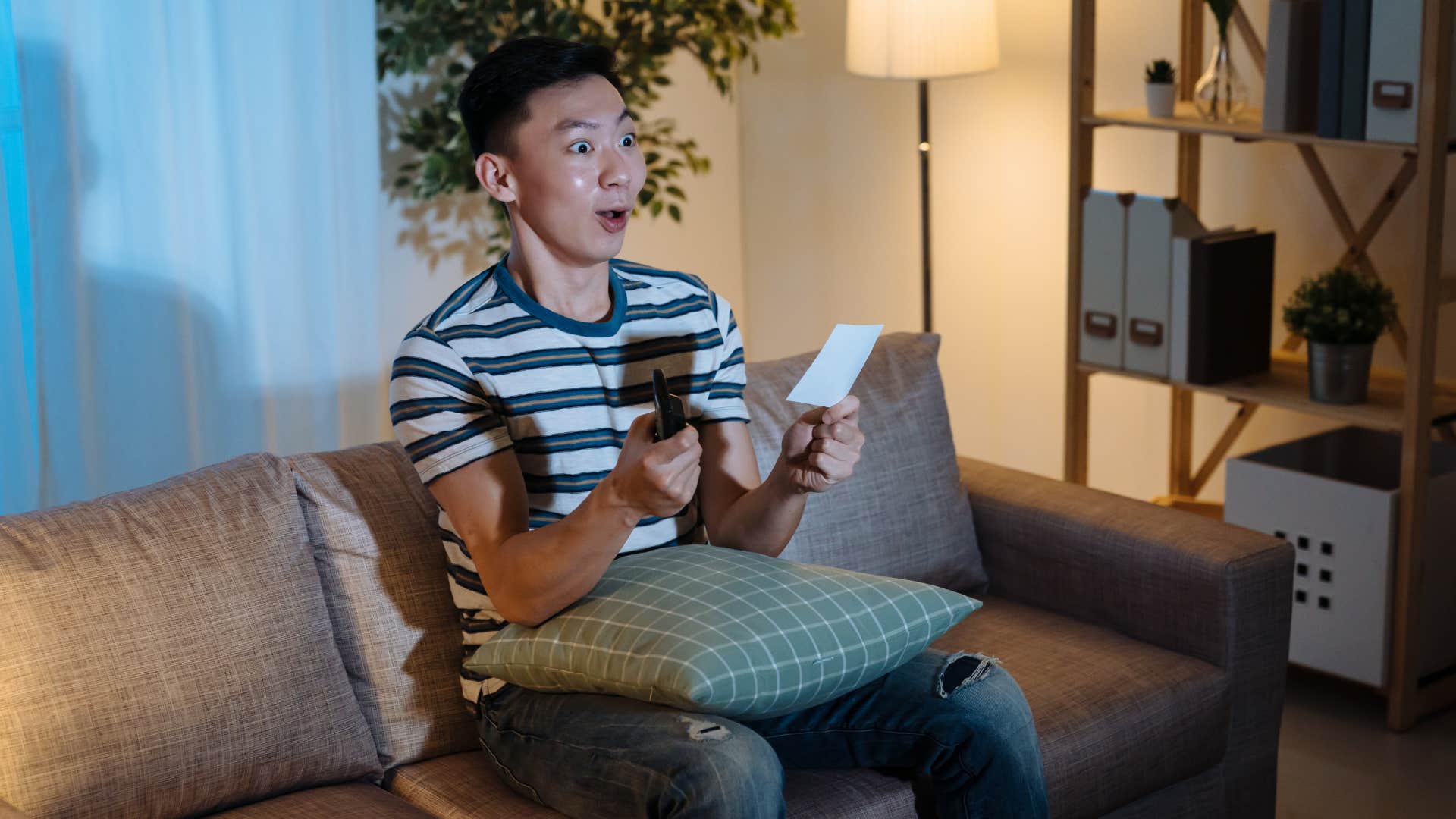 man playing the lottery at home