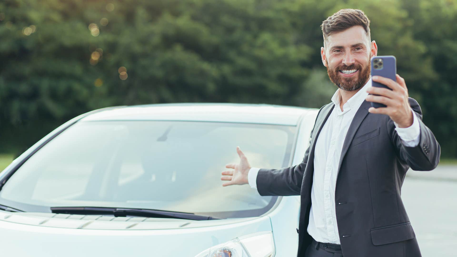 rich man in suit pointing at over the top car 