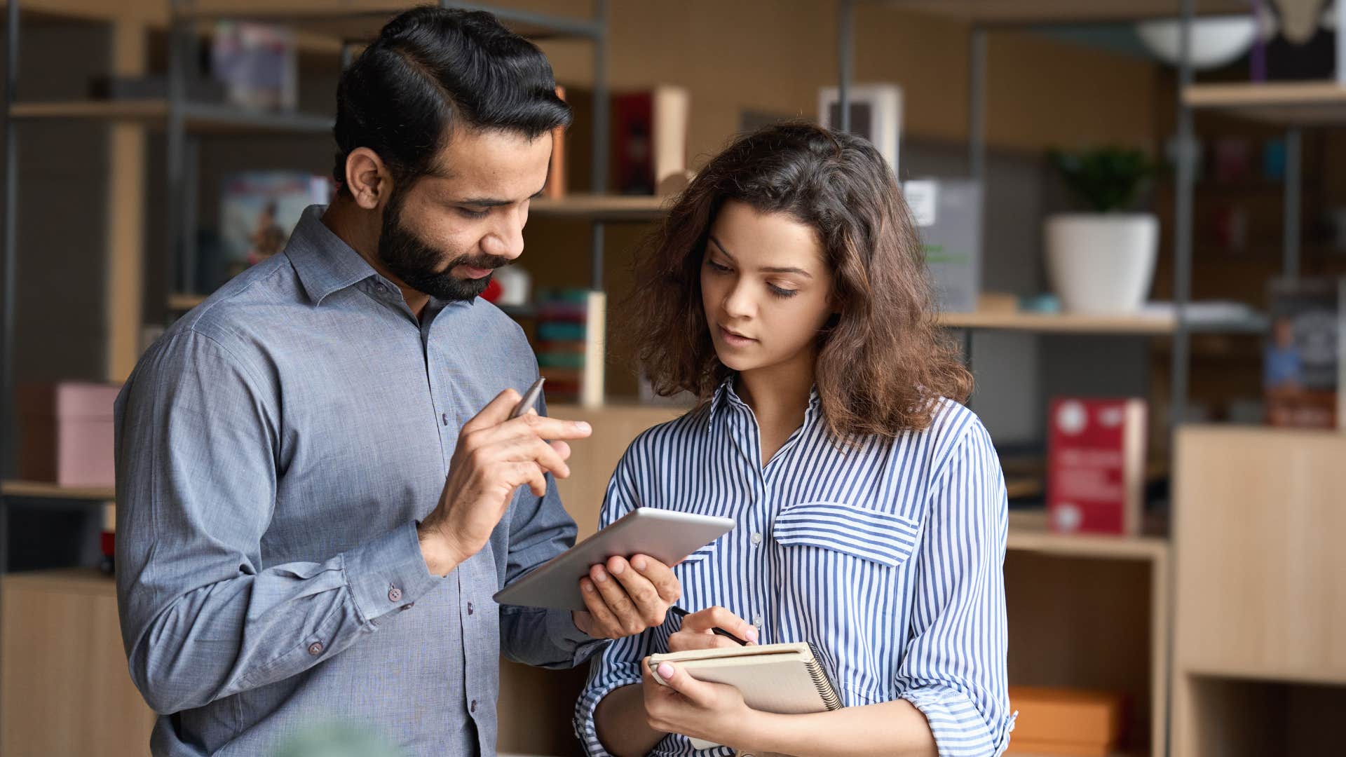 man in blue shirt looking at phone as woman says just check in where are you with things while staring at phone