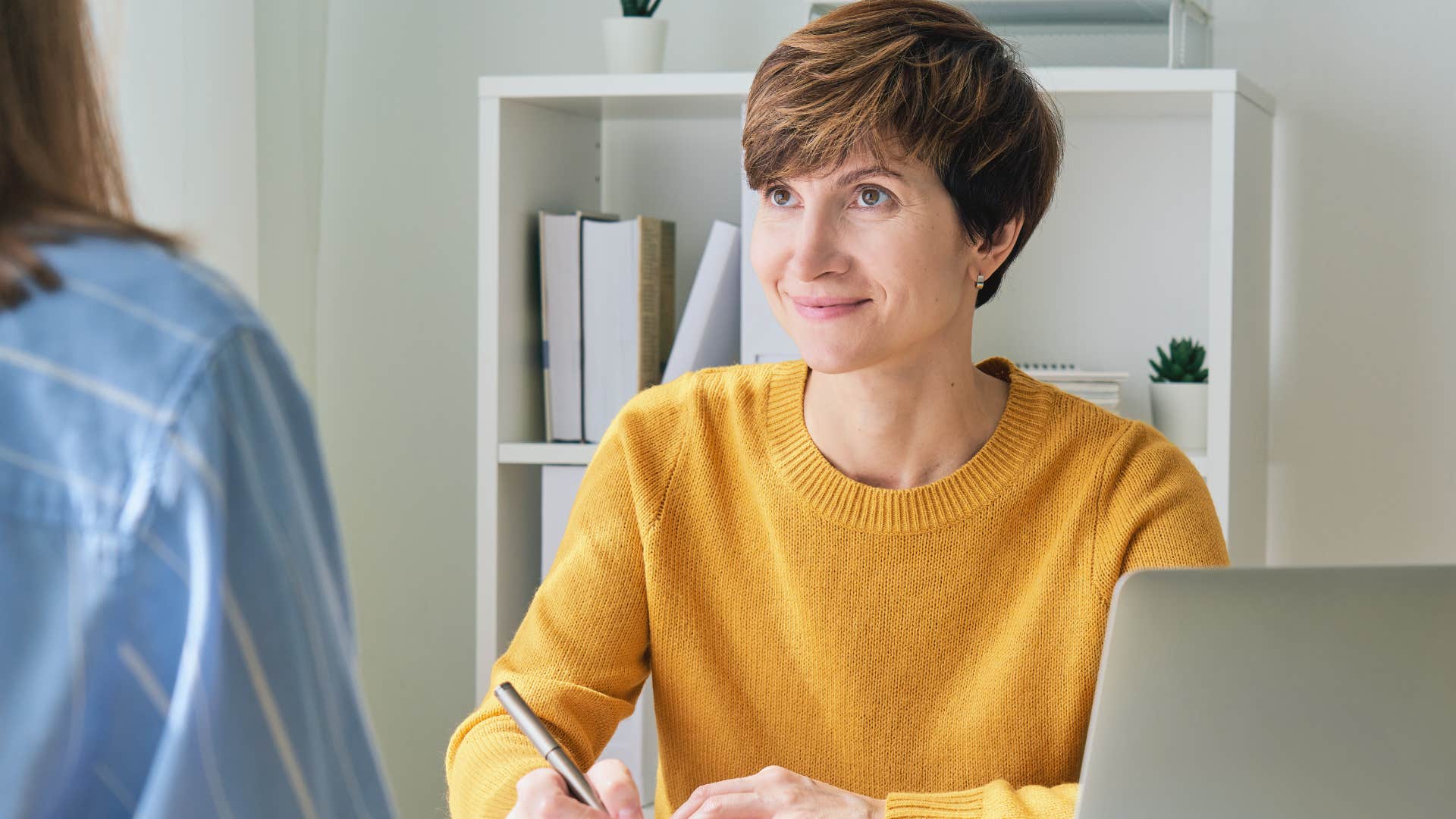 woman in yellow shirt smiling as she says just looping back any updates