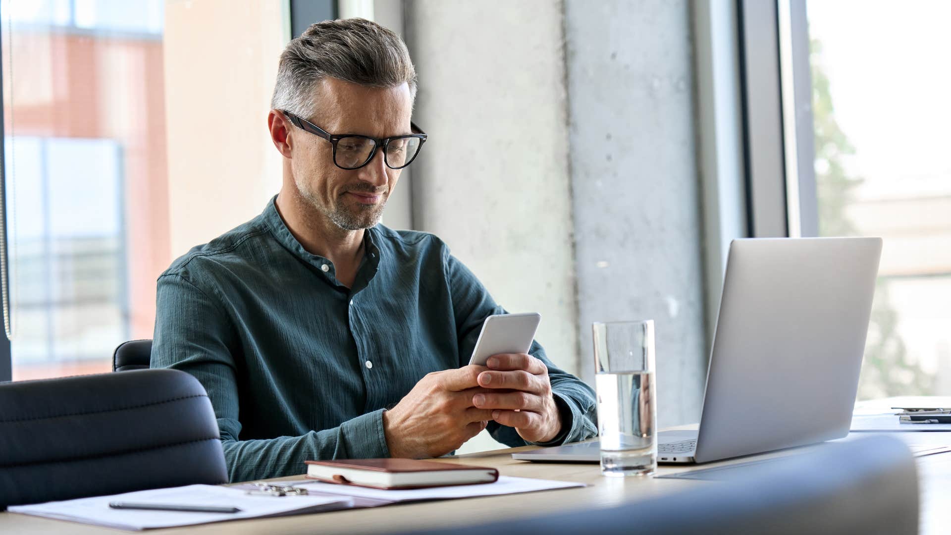 man texting worker please update me when you make progress at he sits at desk