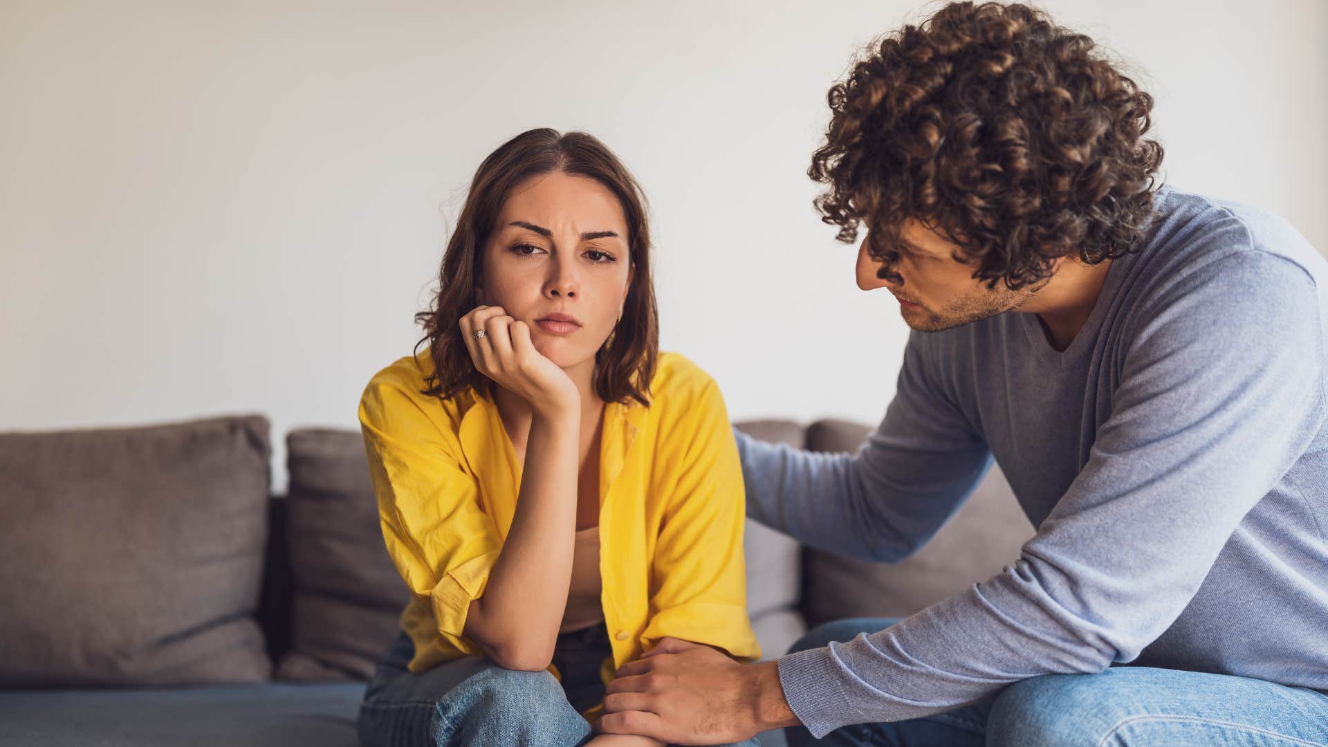 woman in yellow shirt thinking i didn't ask for this as man tries to comfort her