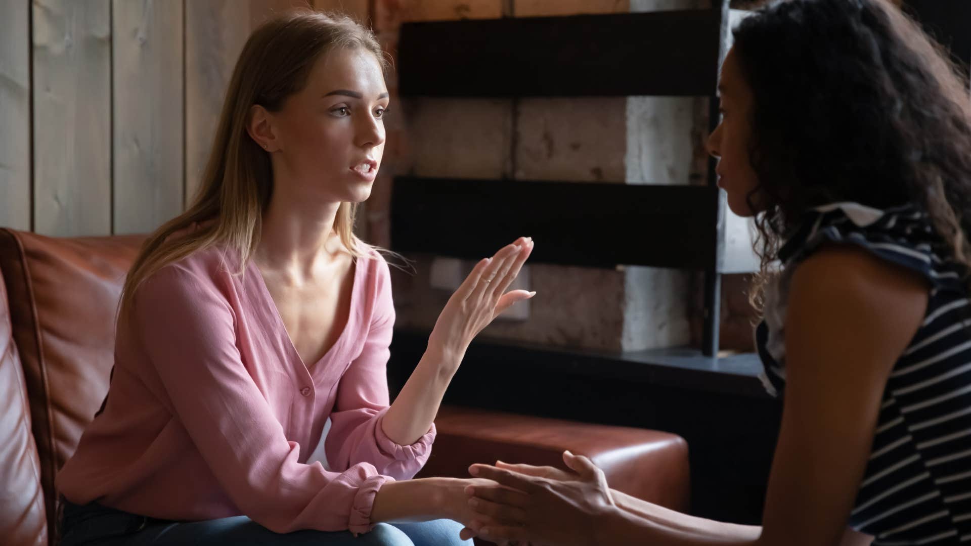 woman in pink sweater saying i didn't mean to hurt you to friend