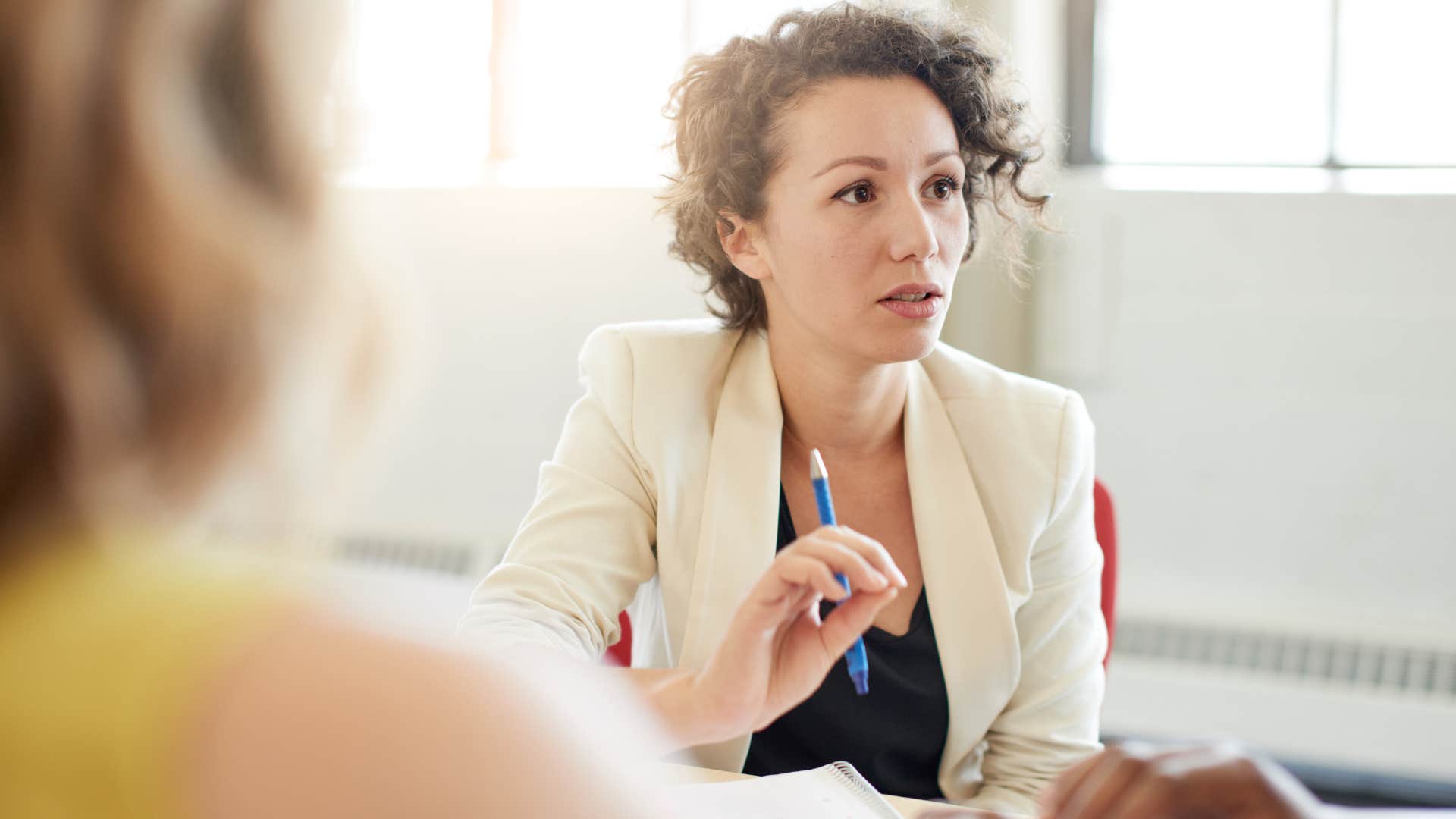 Woman who hates being around people 24/7 sitting in a work meeting.
