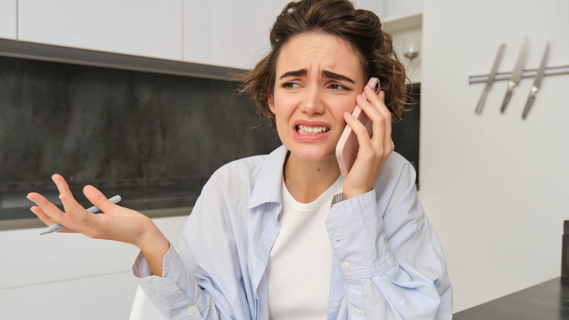 Woman uncomfortable with getting compliments talking on the phone.