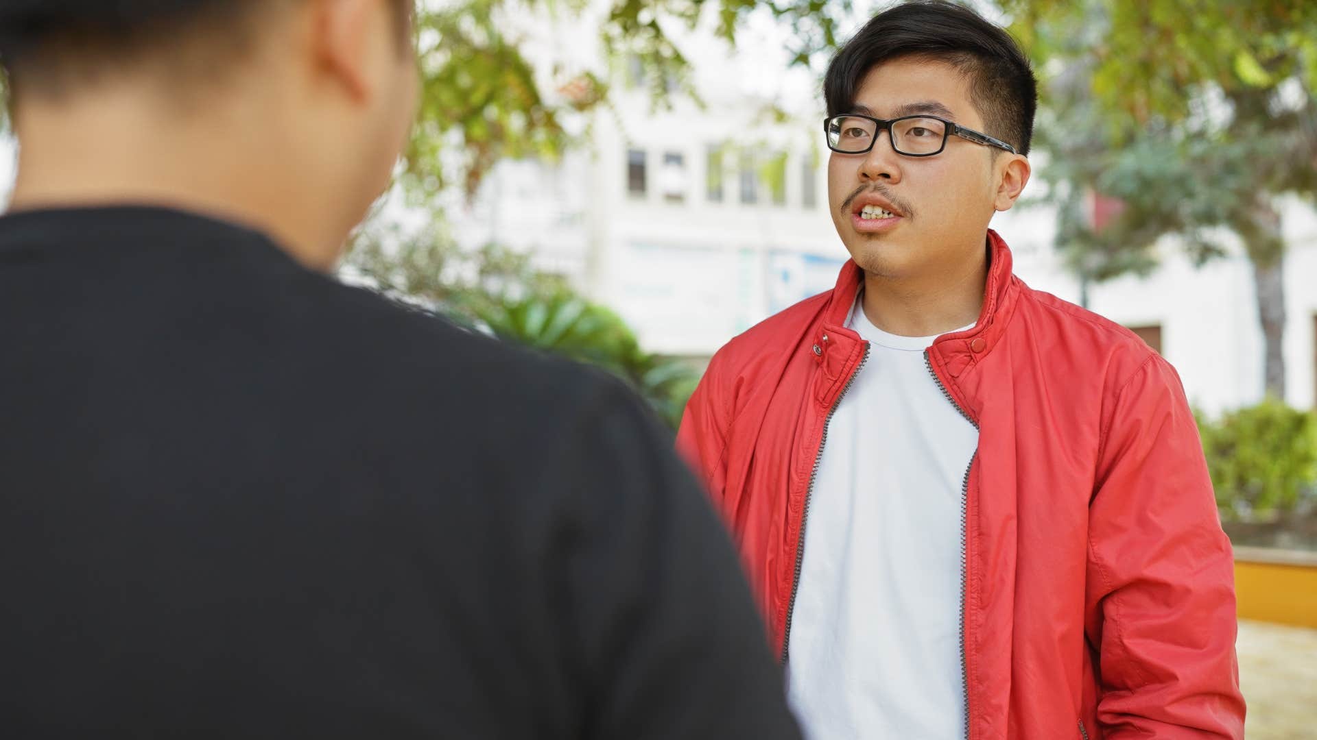 Man engaging in small talk with a friend outside.