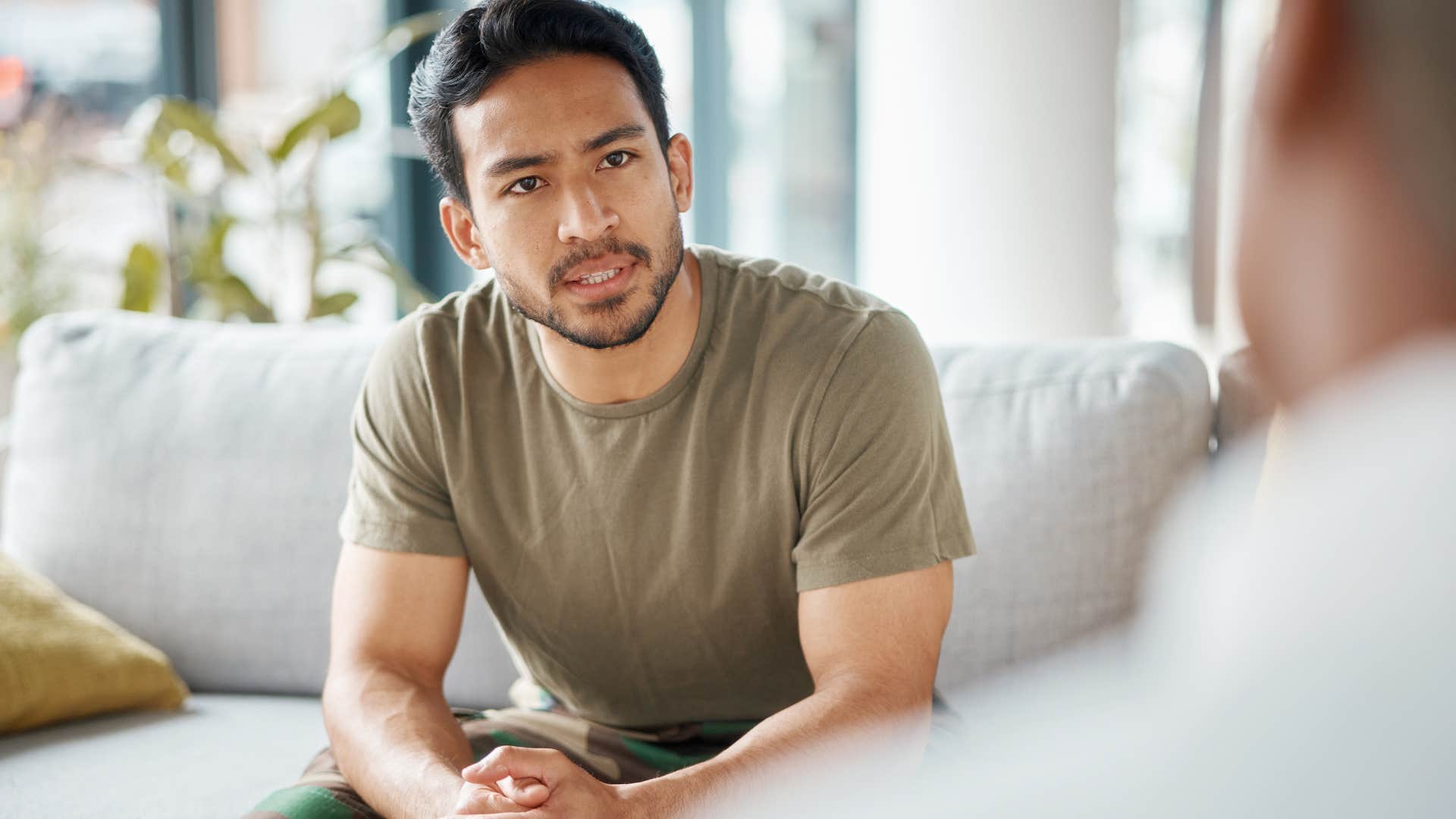 Man who hates talking about their past looking at a therapist.