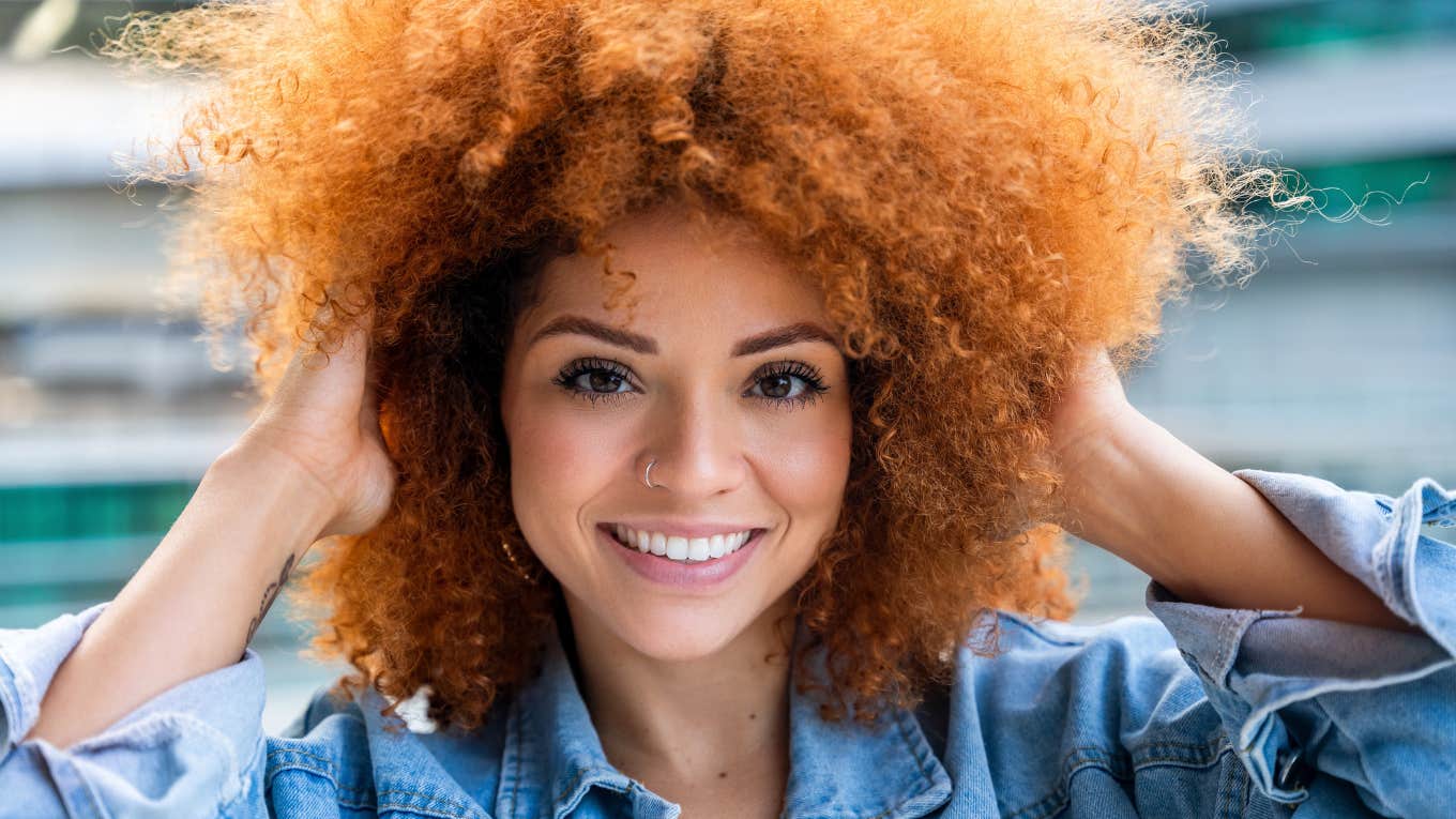 common sense woman smiling with hands in her hair