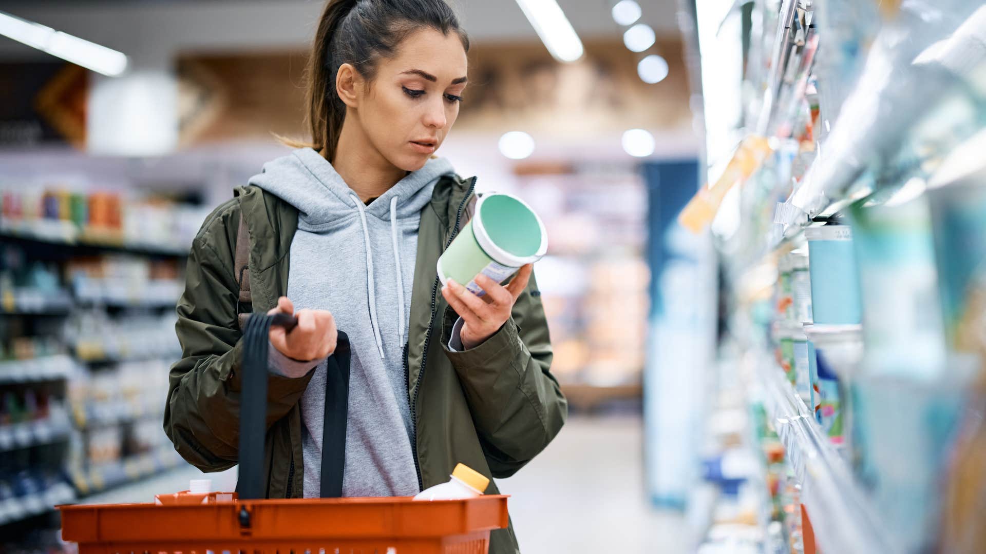 woman reading label of food product in grocery store
