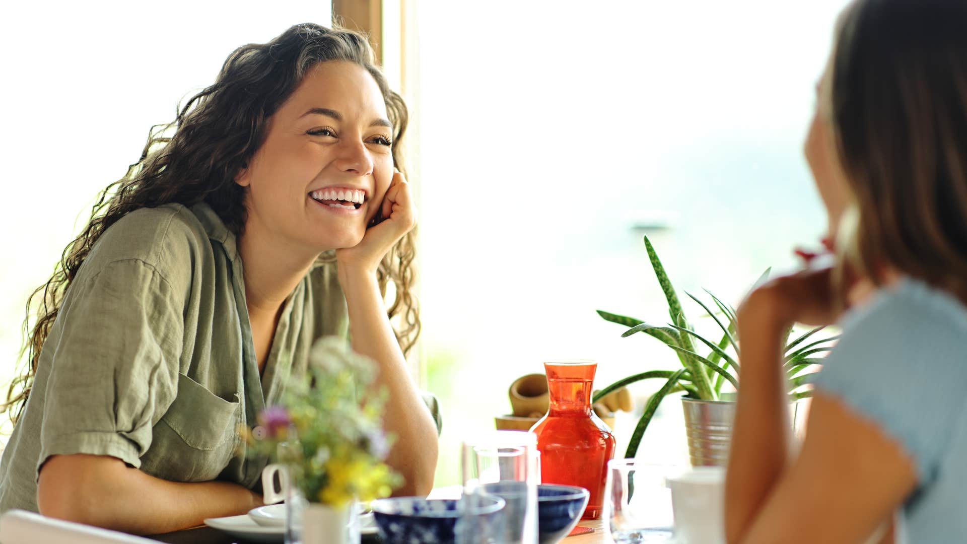 woman smiling with friend at dinner