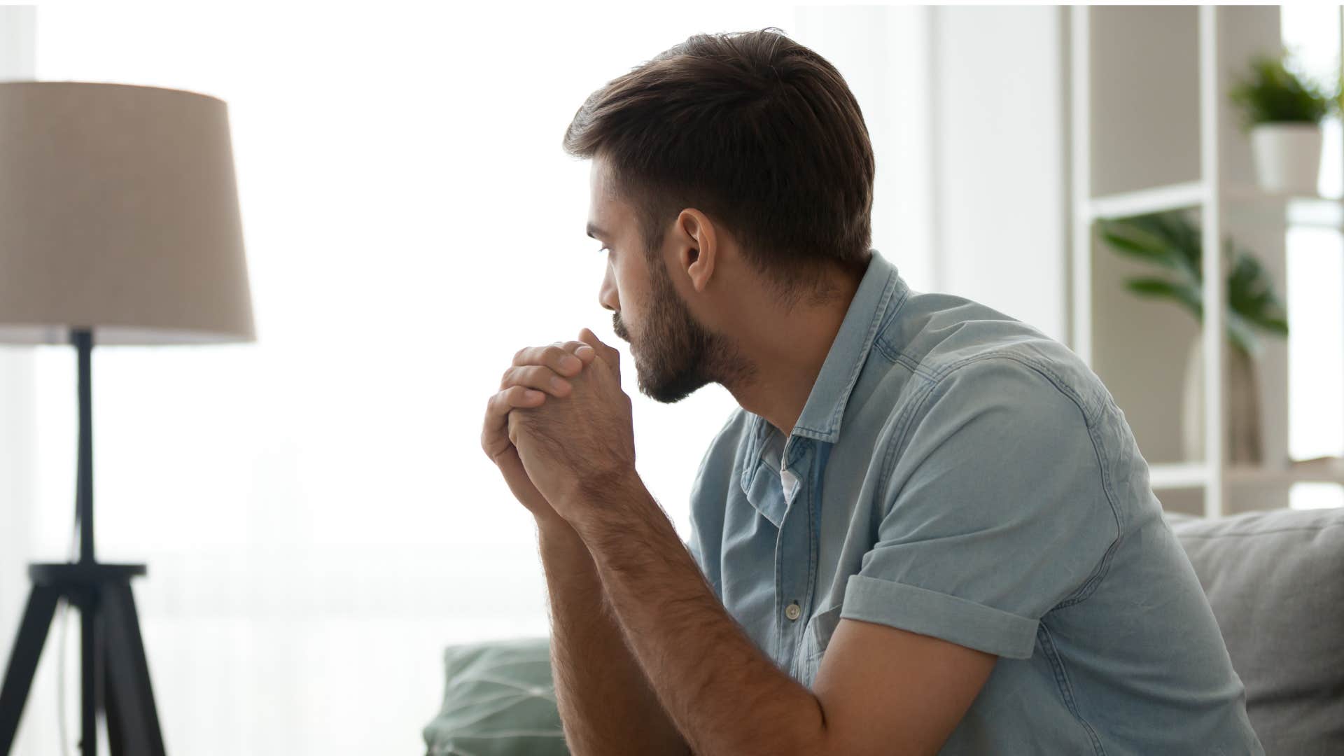 man having emotional disconnection as he looks out window