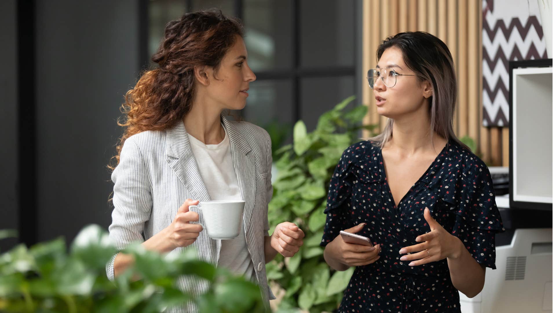 woman in black dress admitting mistakes without fear as she talks to coworker