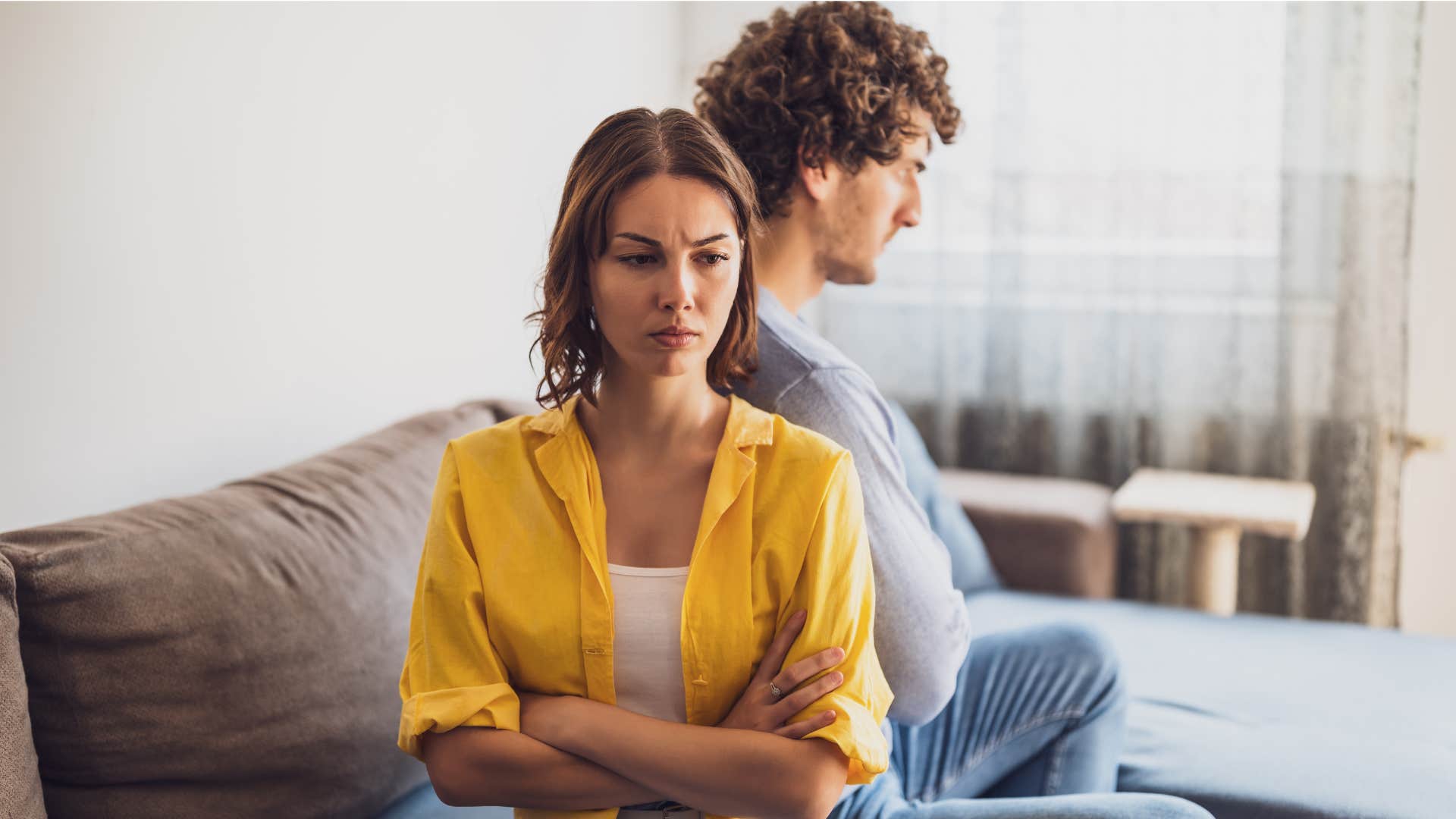 woman in yellow shirt avoiding accountability as she turns away from man