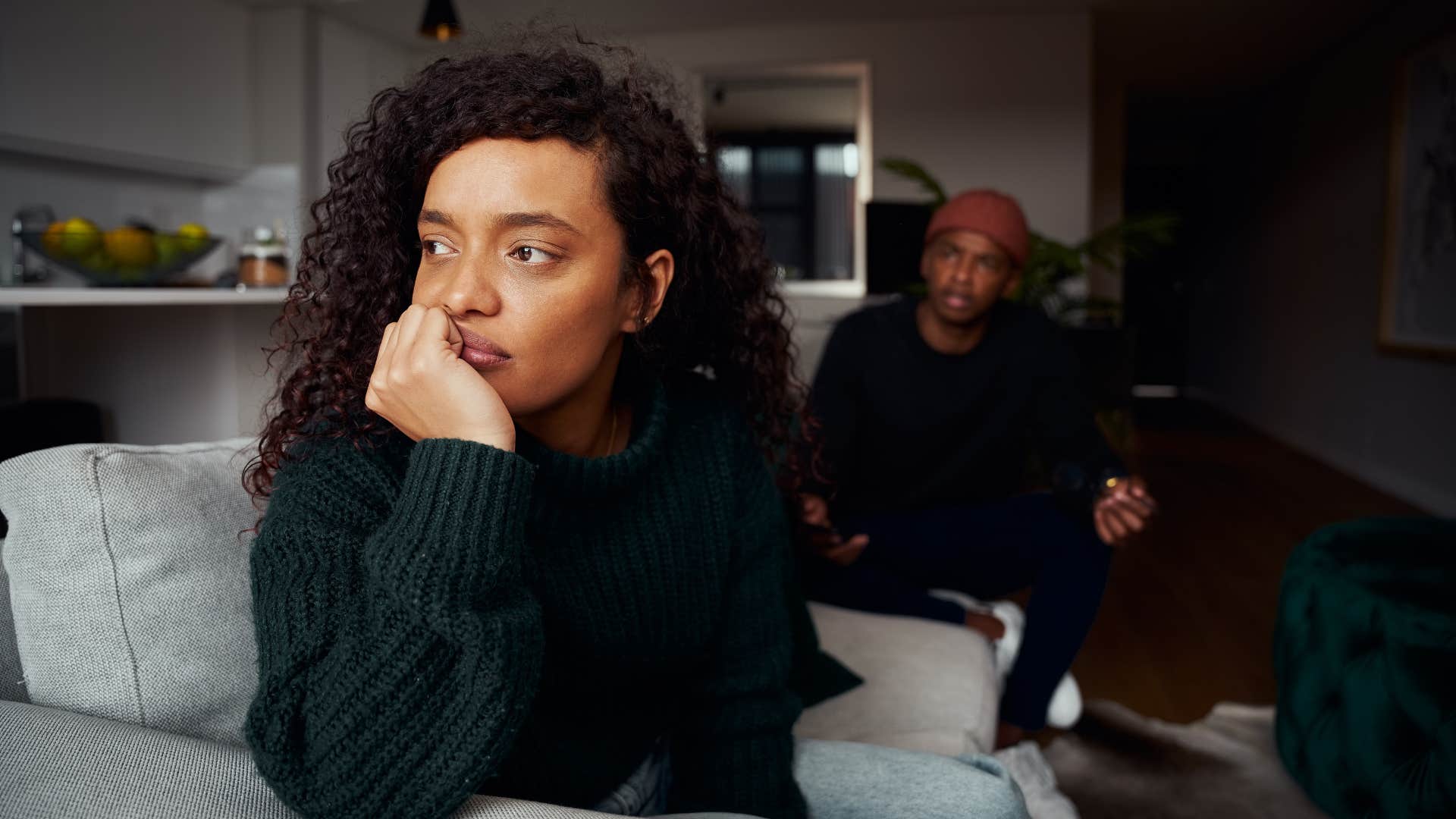woman in green shirt shutting down emotionally as man tries to talk to her