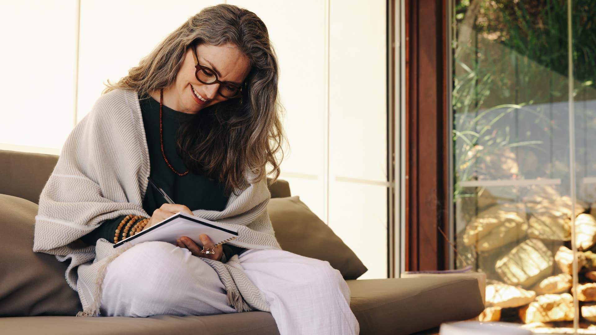 woman in black shirt creating a chores chart as she writes things down
