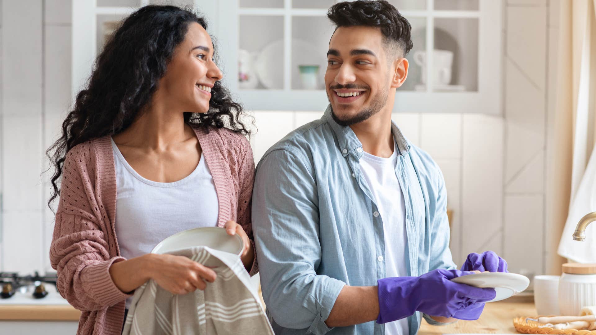 couple smiling and doing household labor together