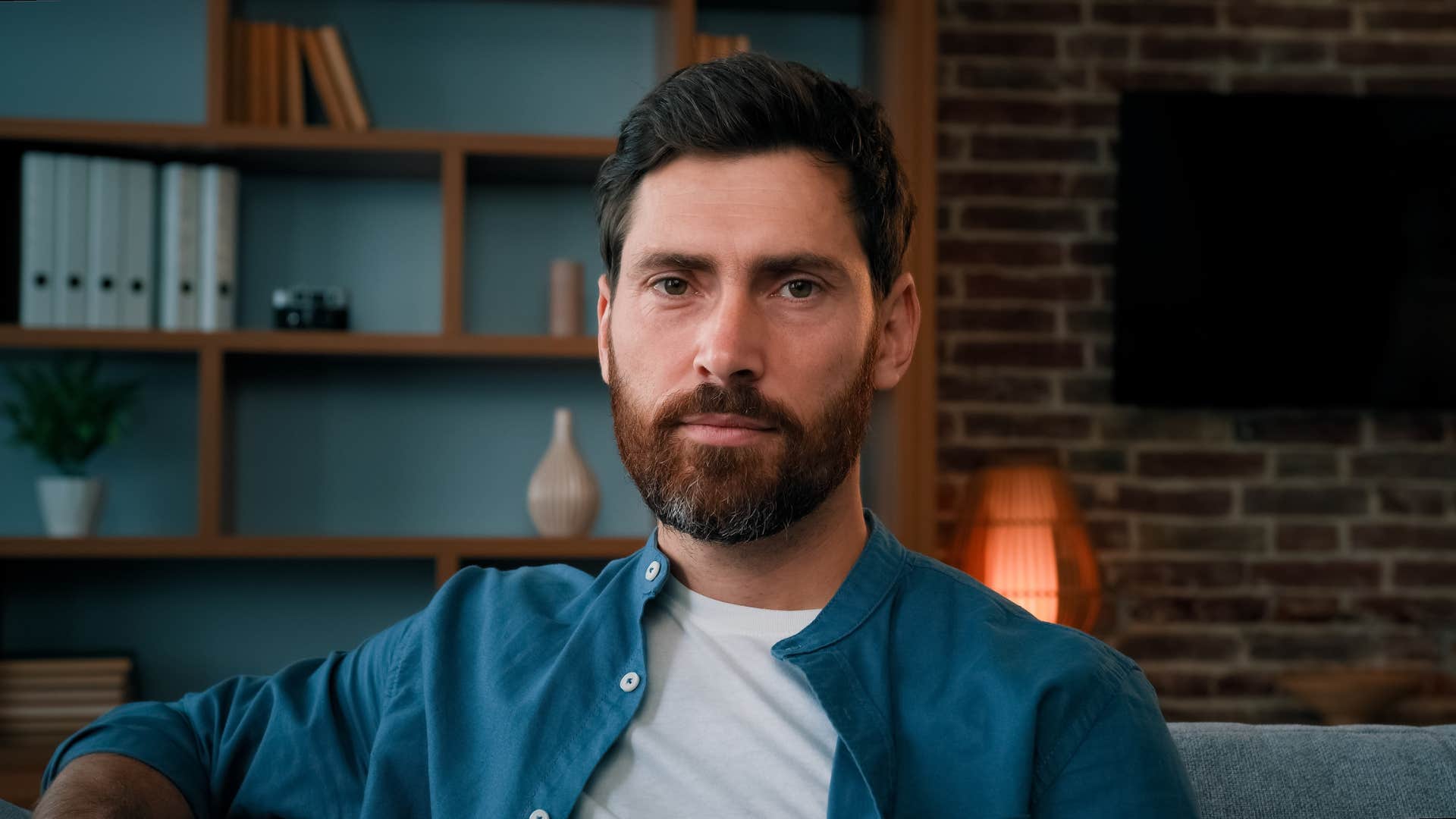 serious man sitting on couch at home