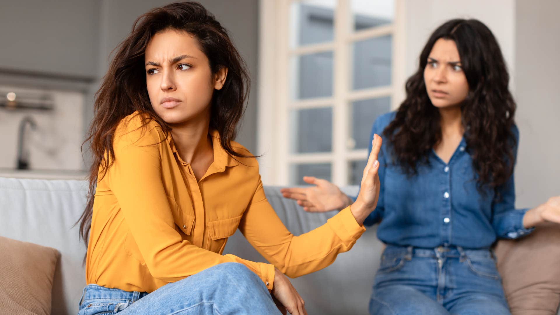 Upset woman looking at her friend who can dismiss other people's needs.
