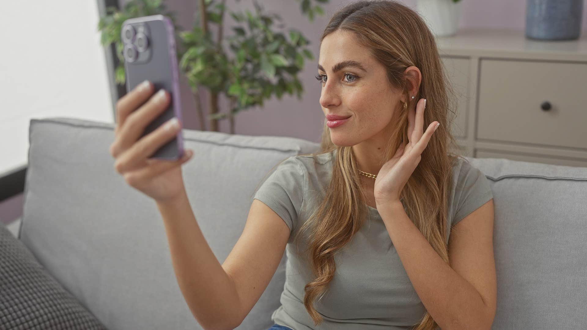Woman who flaunts their wealth online sitting on a couch.