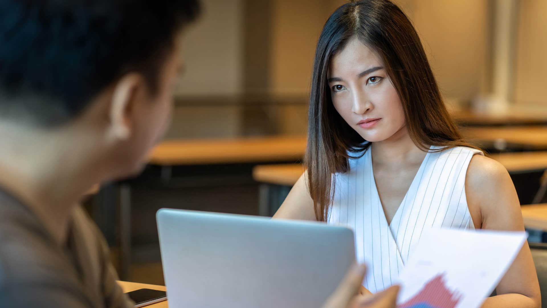 Woman who can weaponize their weaknesses talking to a co-worker.