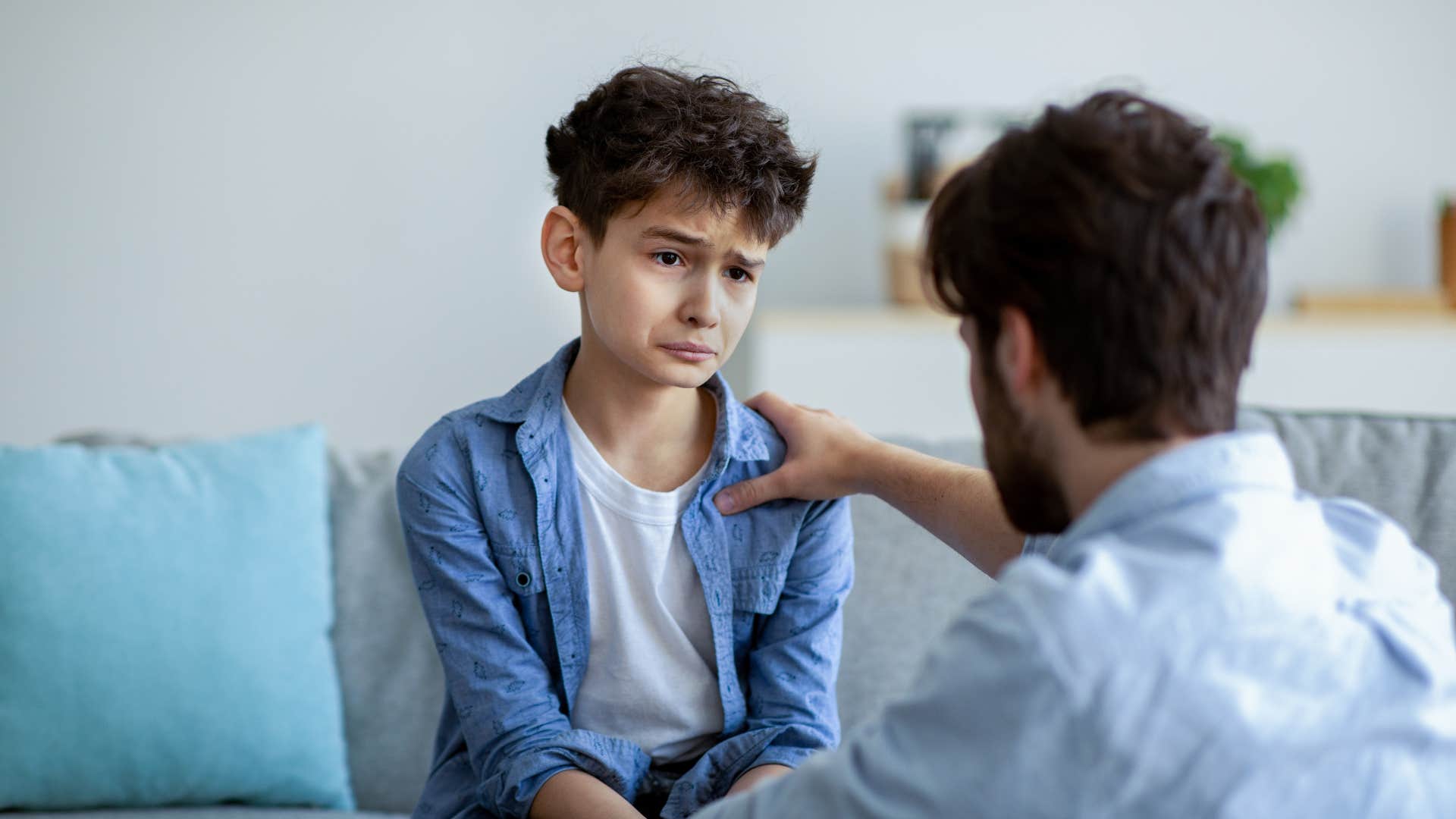 dad disciplining upset son for lying