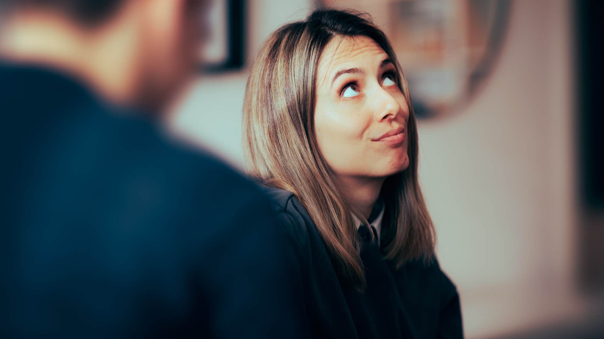 woman rolls her eyes as she has dismissive body language towards man