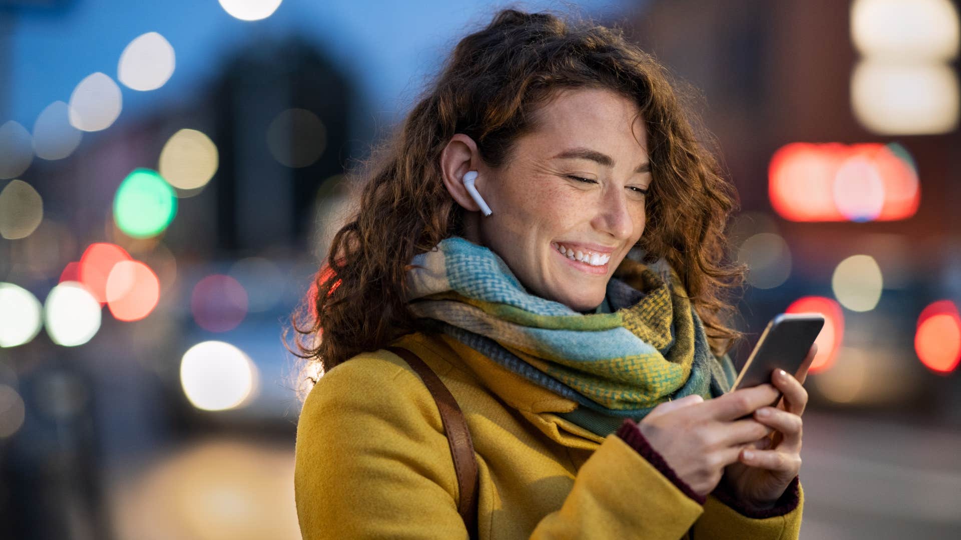 woman in yellow jacket checking up on man's well being as she texts him on the phone