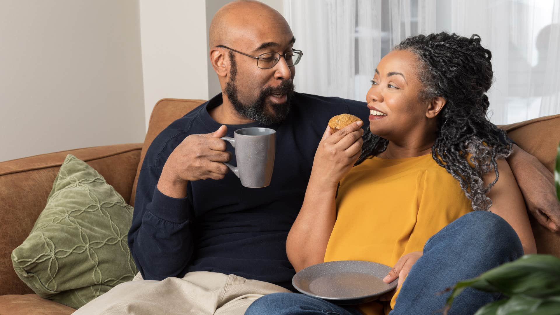Man asking "How are you feeling?" to his wife on the couch.