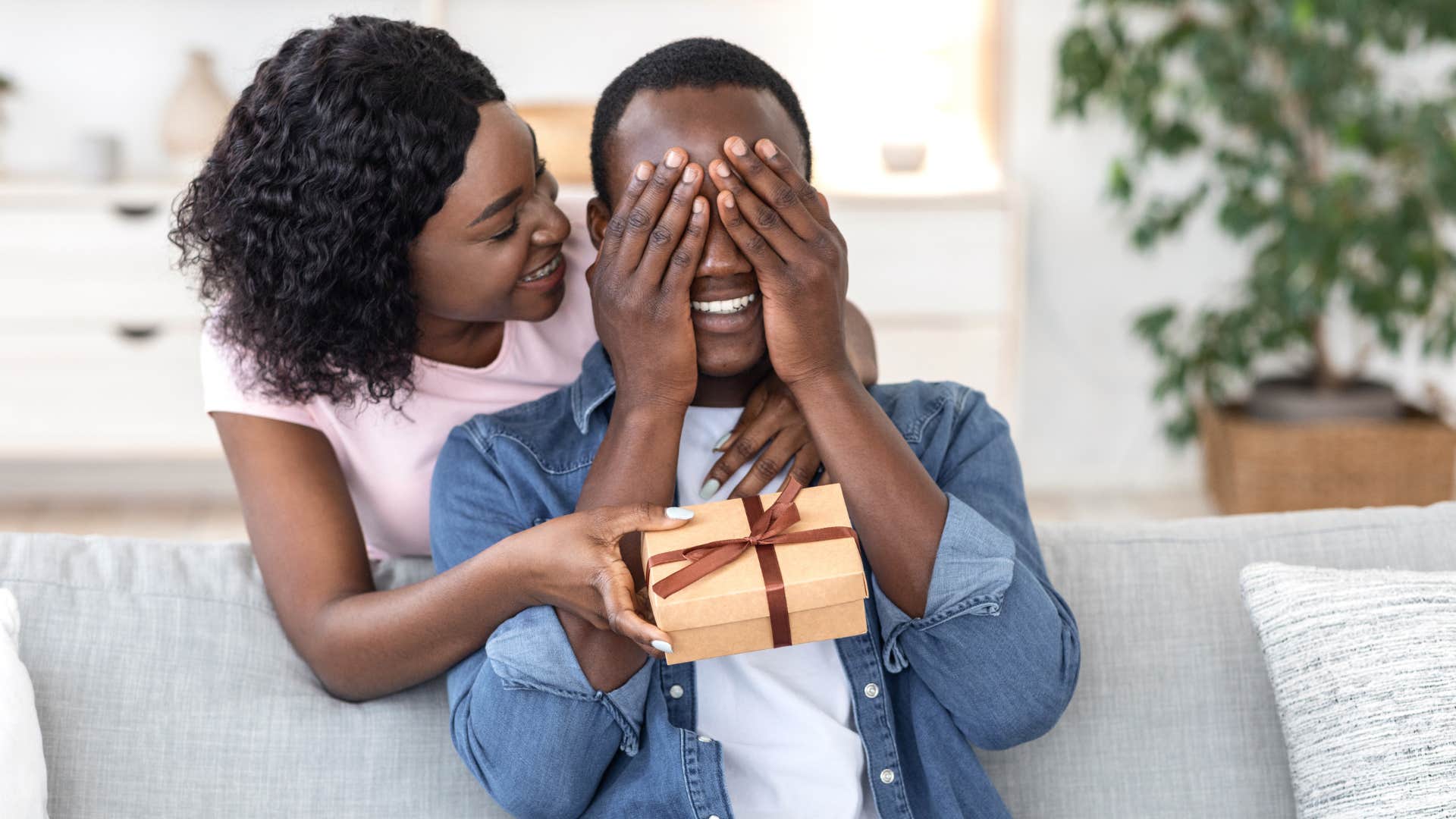 woman in pink shirt giving without keeping score as she gives man present