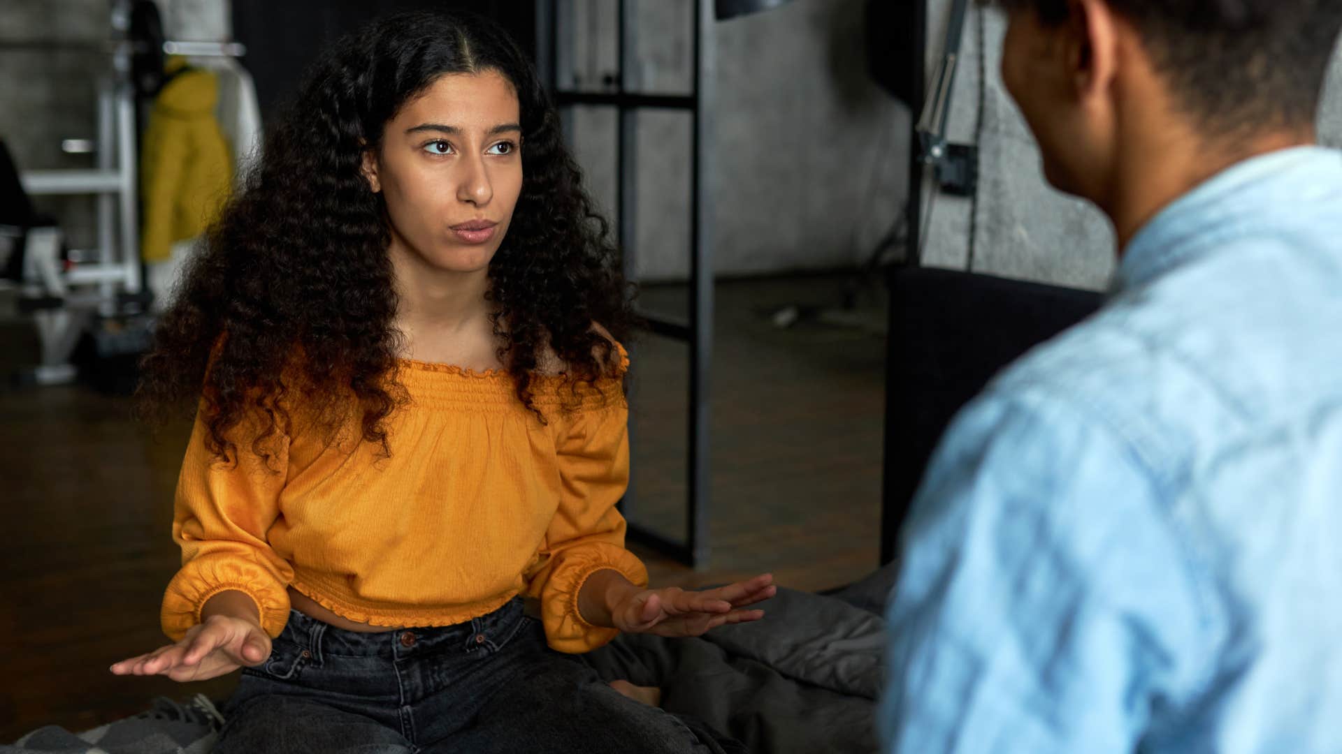 woman in orange respects boundaries as she talks to man