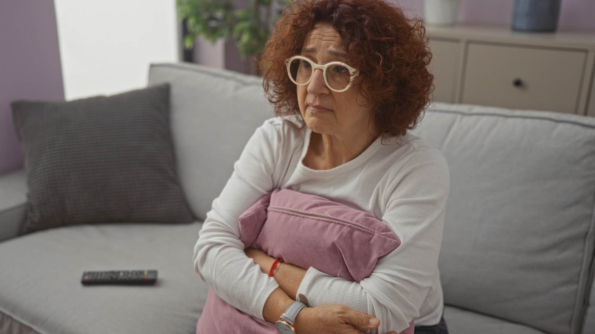 Upset woman thinking "I've done so much for him" on the couch.