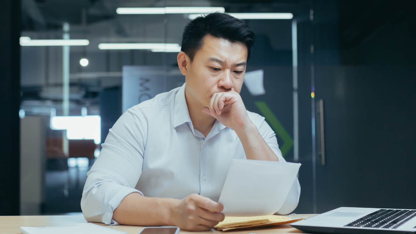 Worker looks stressed while reading.