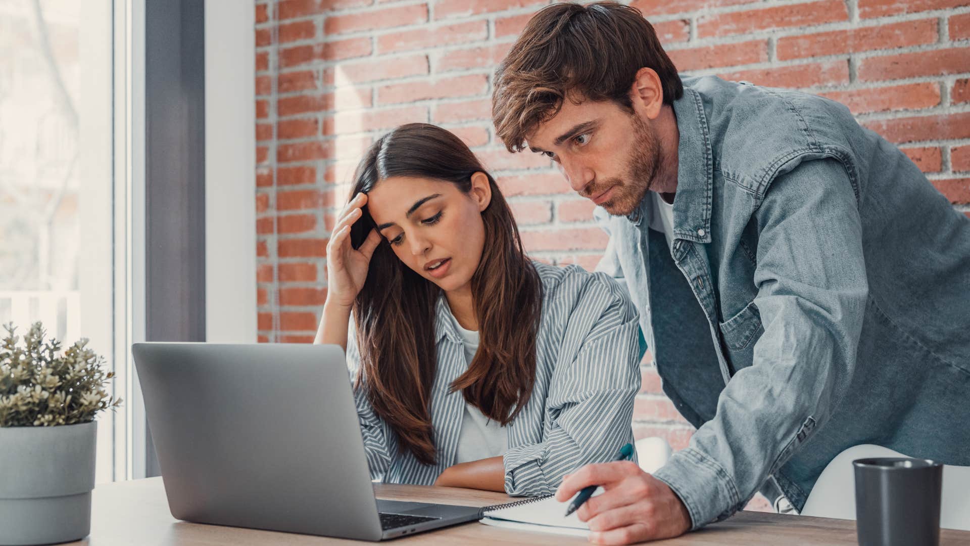 Couple who doesn't have the money to travel looking worried.