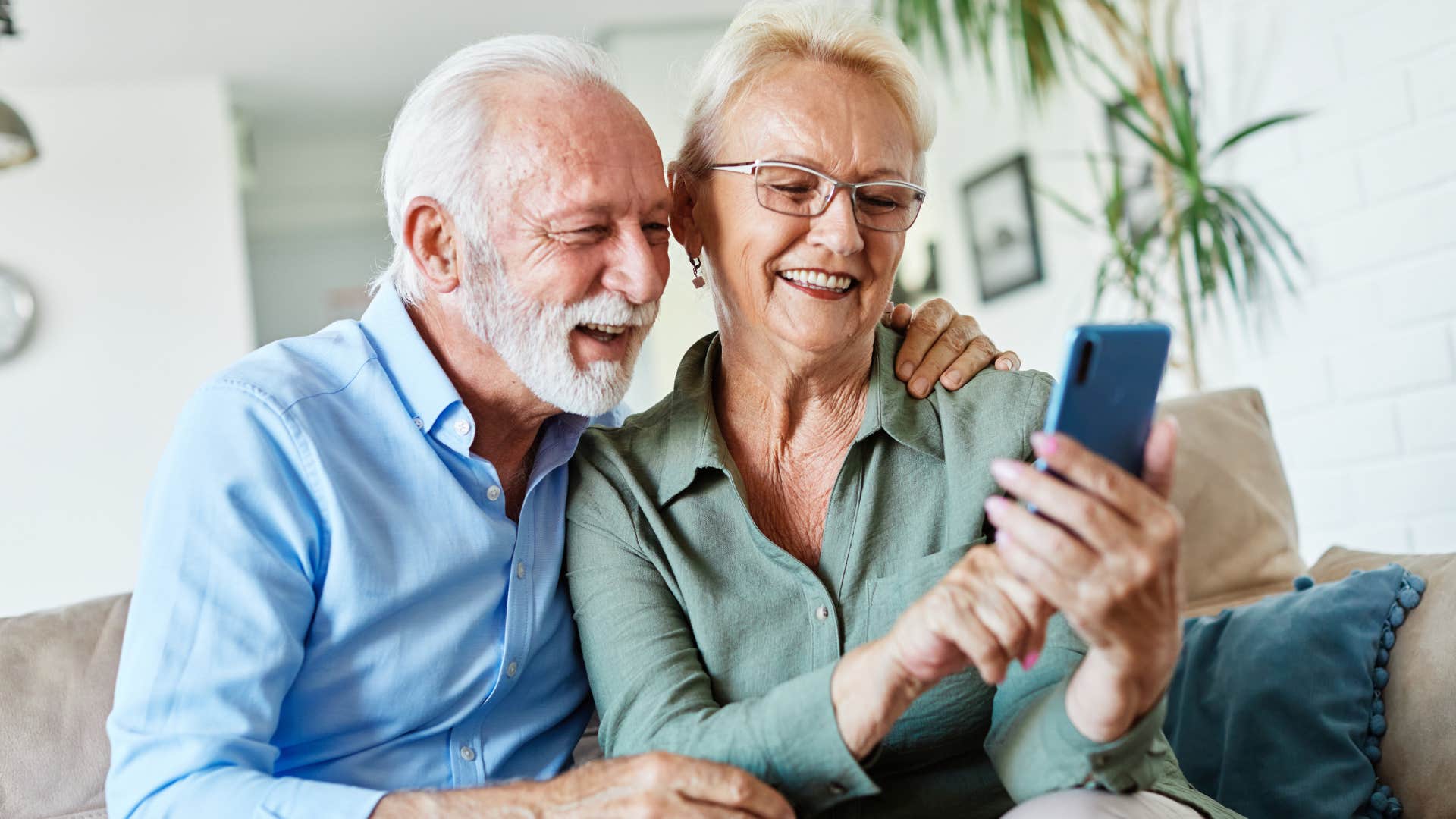 Older couple looking at their kids who don't live nearby on their phone.