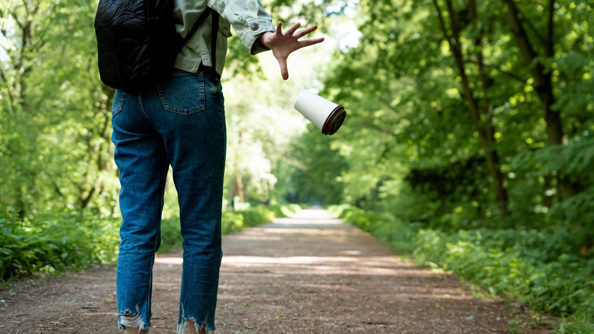 woman contributing to anthropogenic pollution by littering