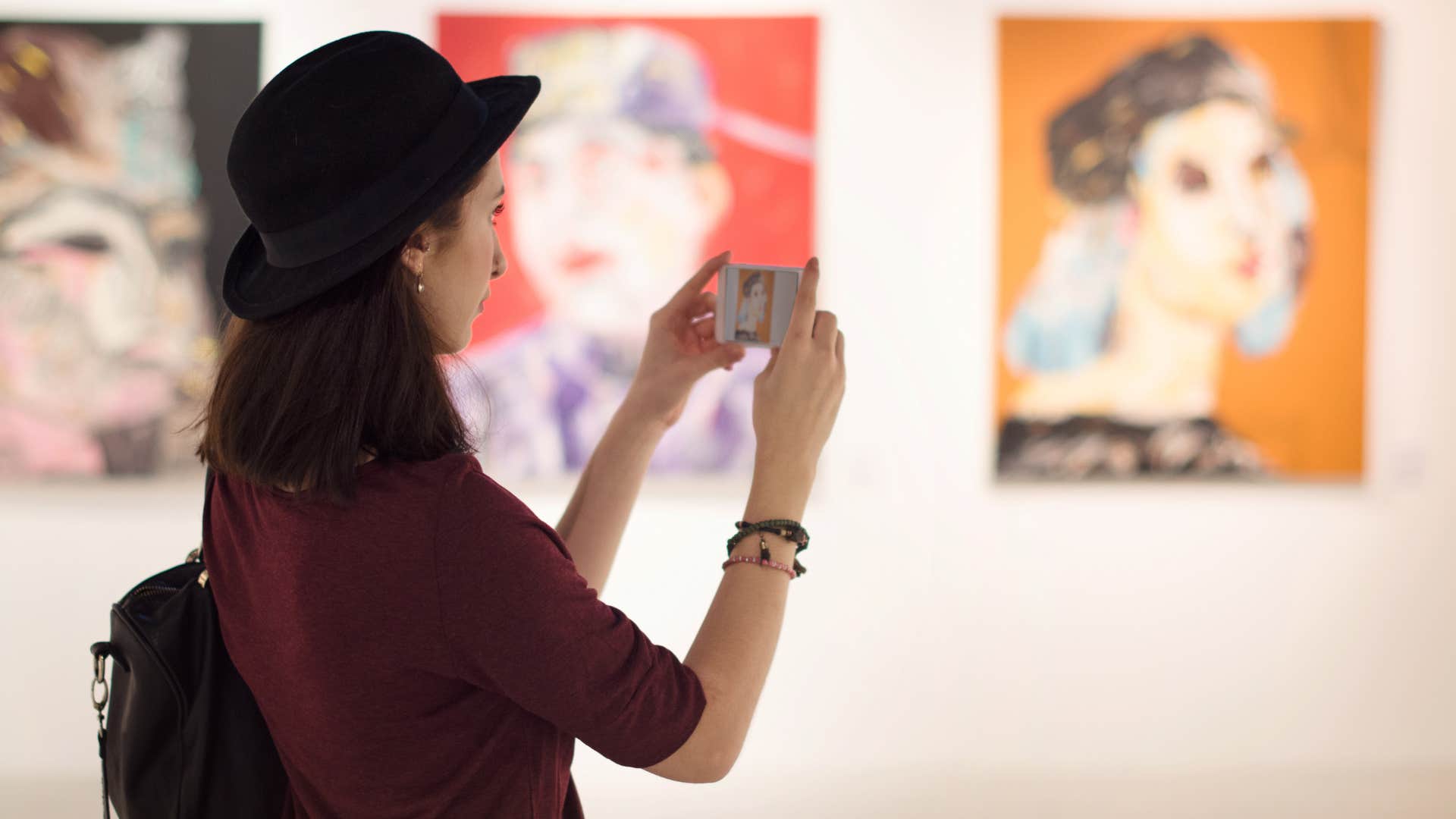 woman taking a picture of a mimesis art gallery