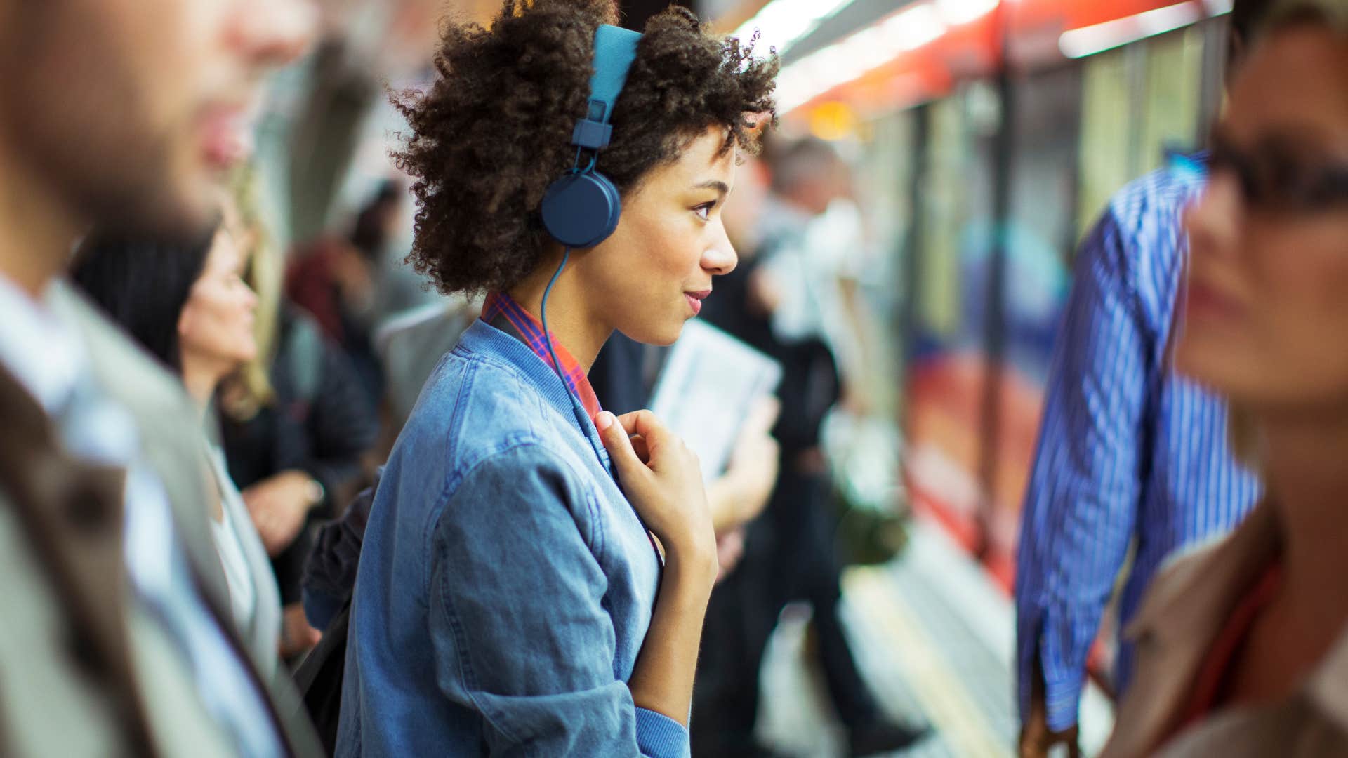 Woman wearing headphones in the subway.