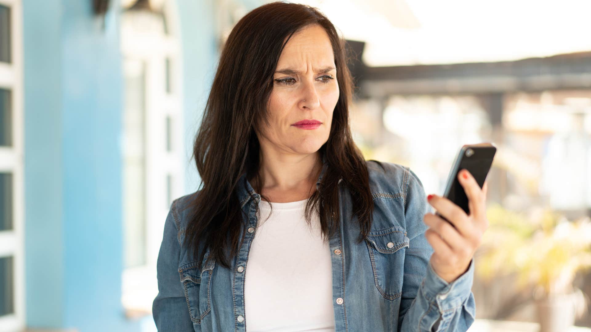 Woman annoyed about someone texting over calling on her phone.