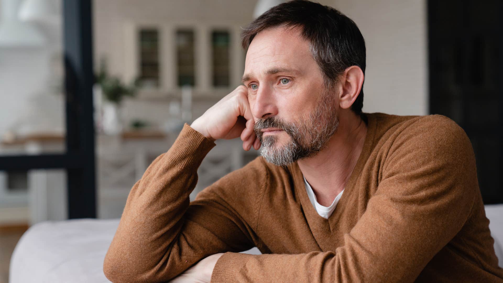 Man who feels invisible looking out a window.