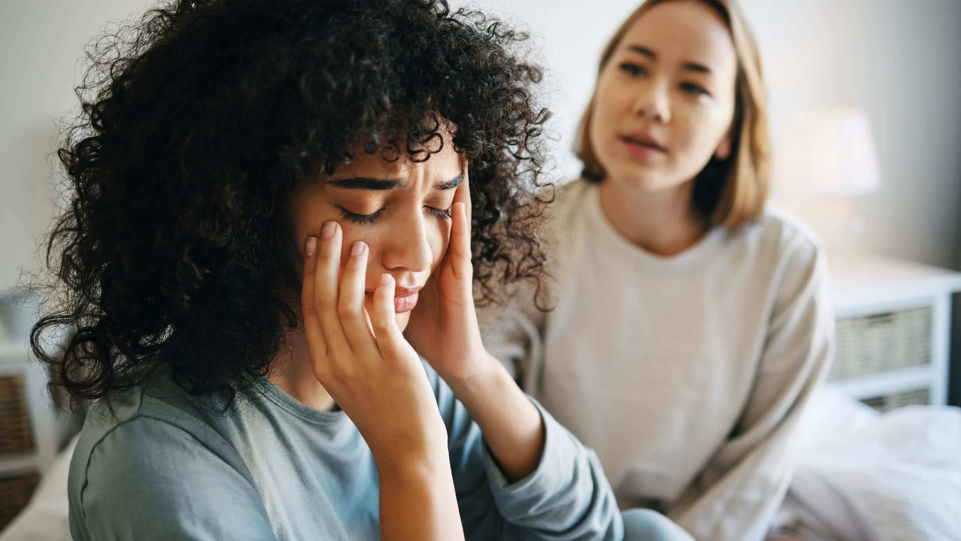 Woman who rewrites history crying with a friend.