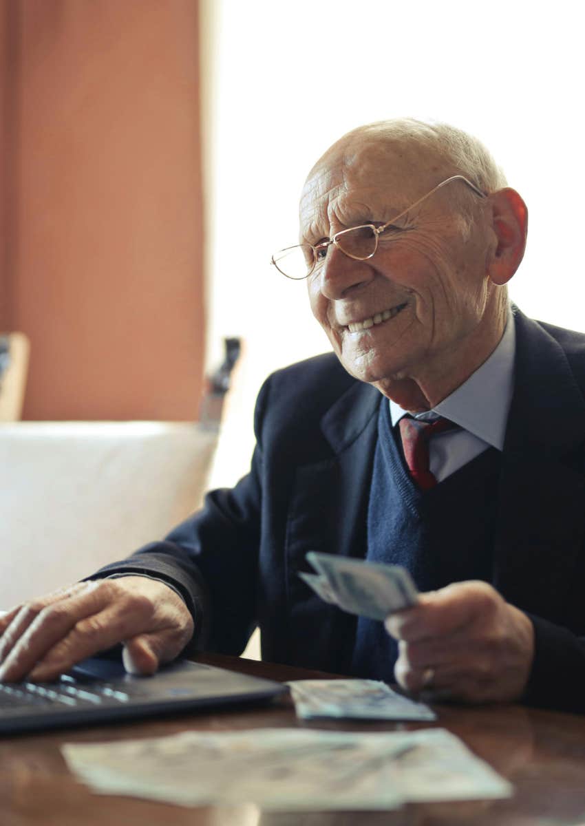 elderly man working with money