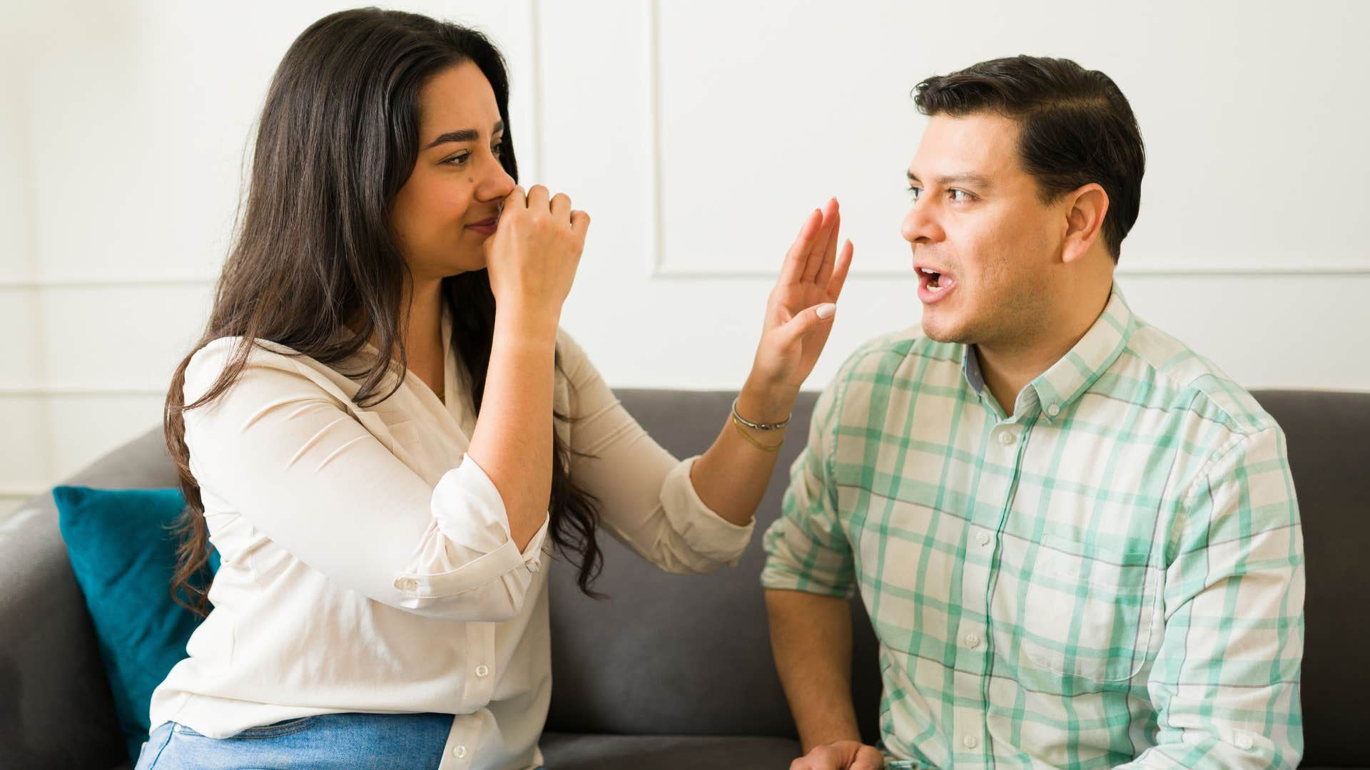 Woman holding her nose next to a man with bad breath.