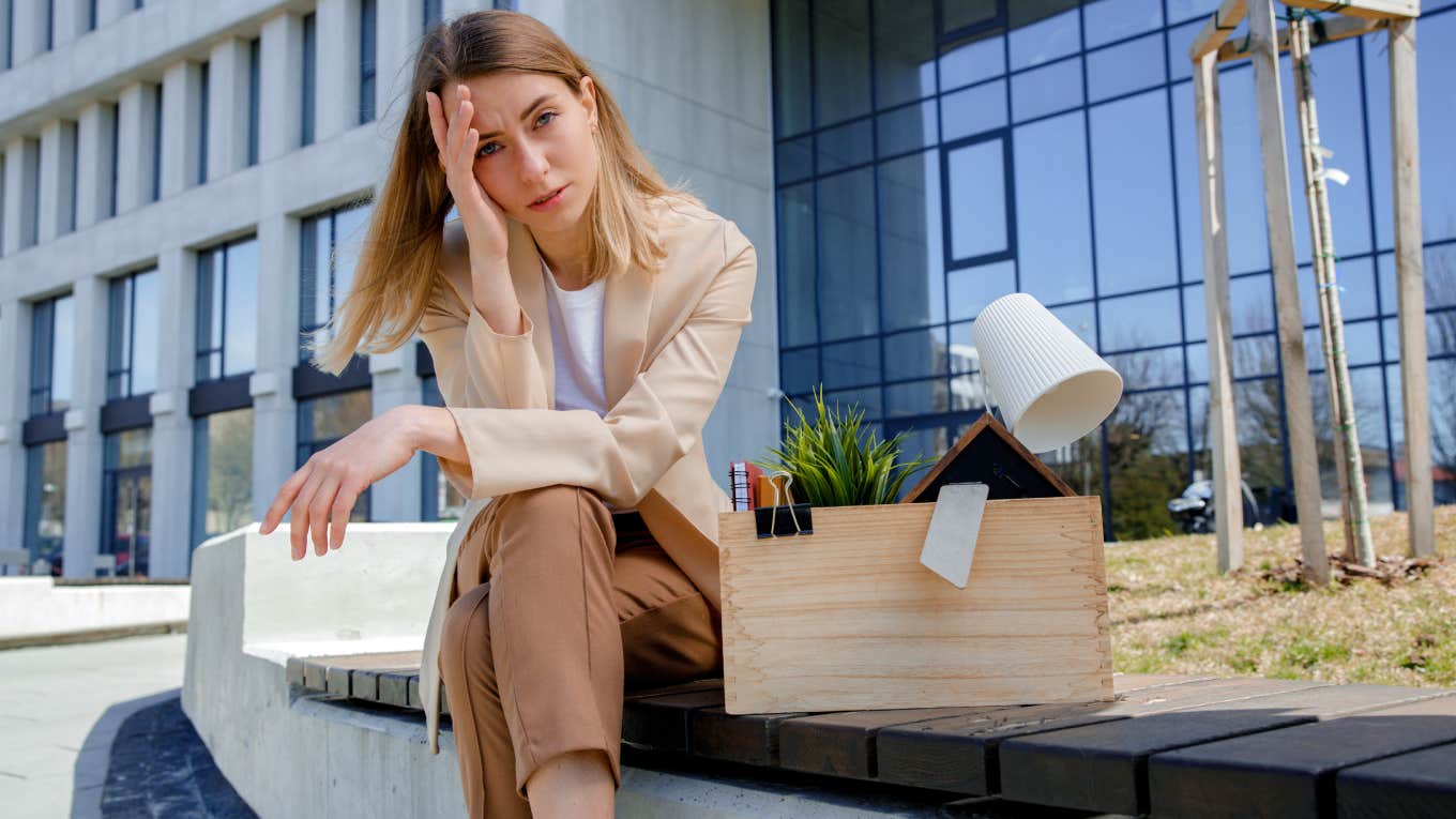 upset employee sitting outside of office after getting fired