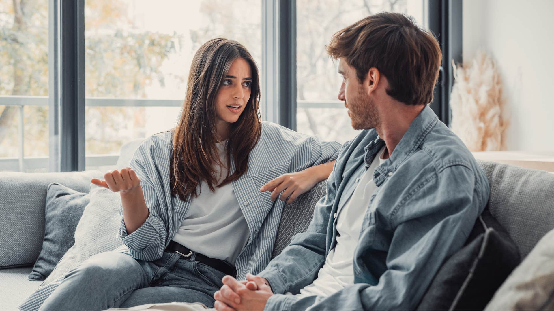 woman telling man in white shirt i already know this as they sit on couch