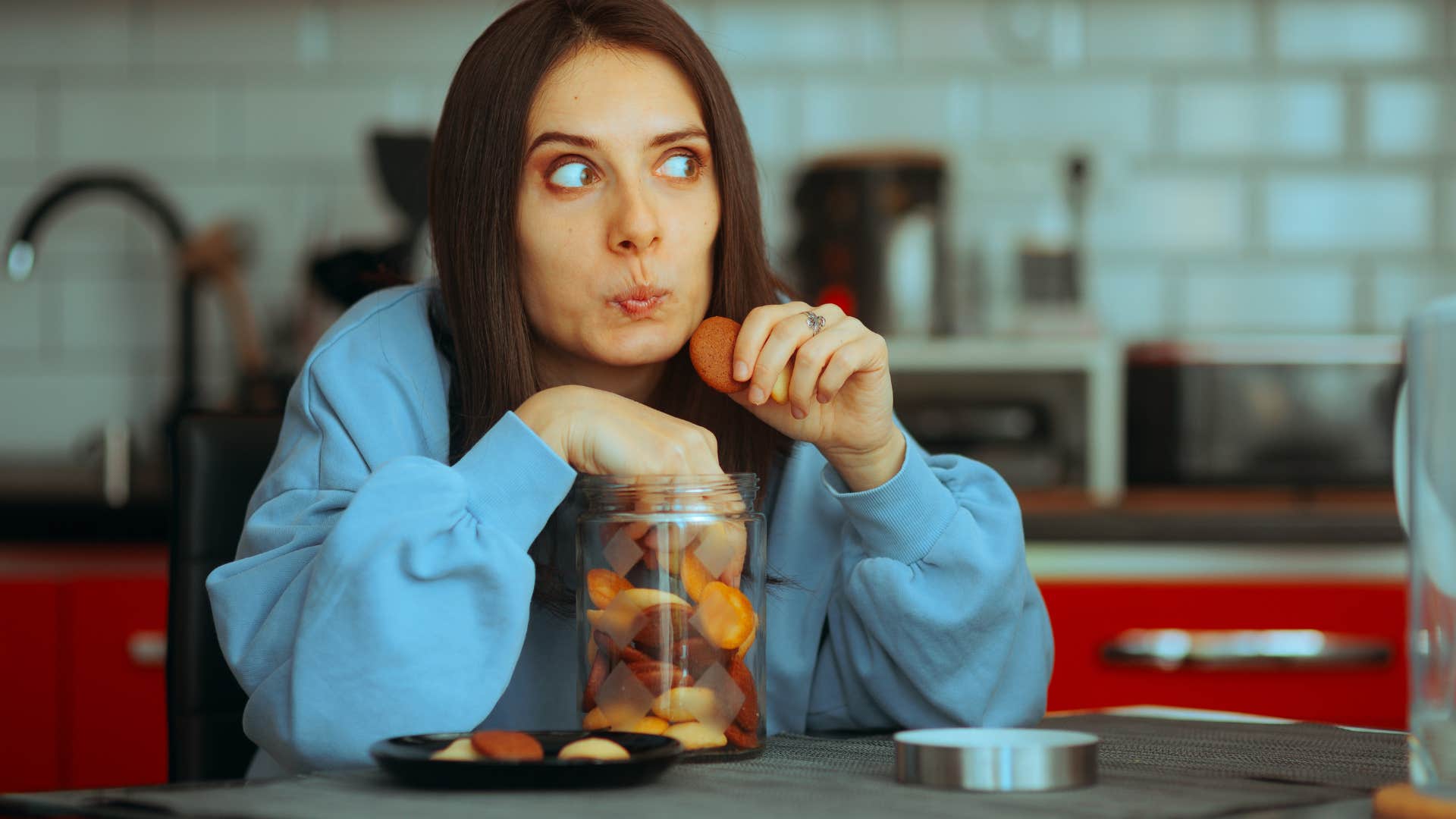 woman emotionally eating in the kitchen