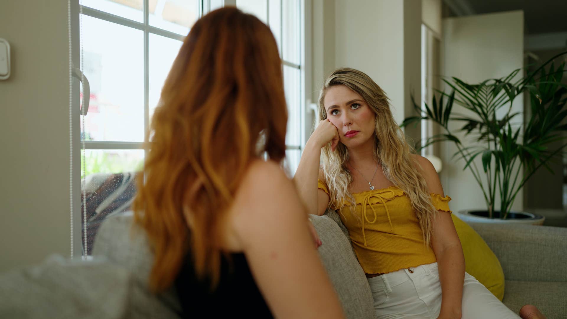 woman having conversation with friend on couch